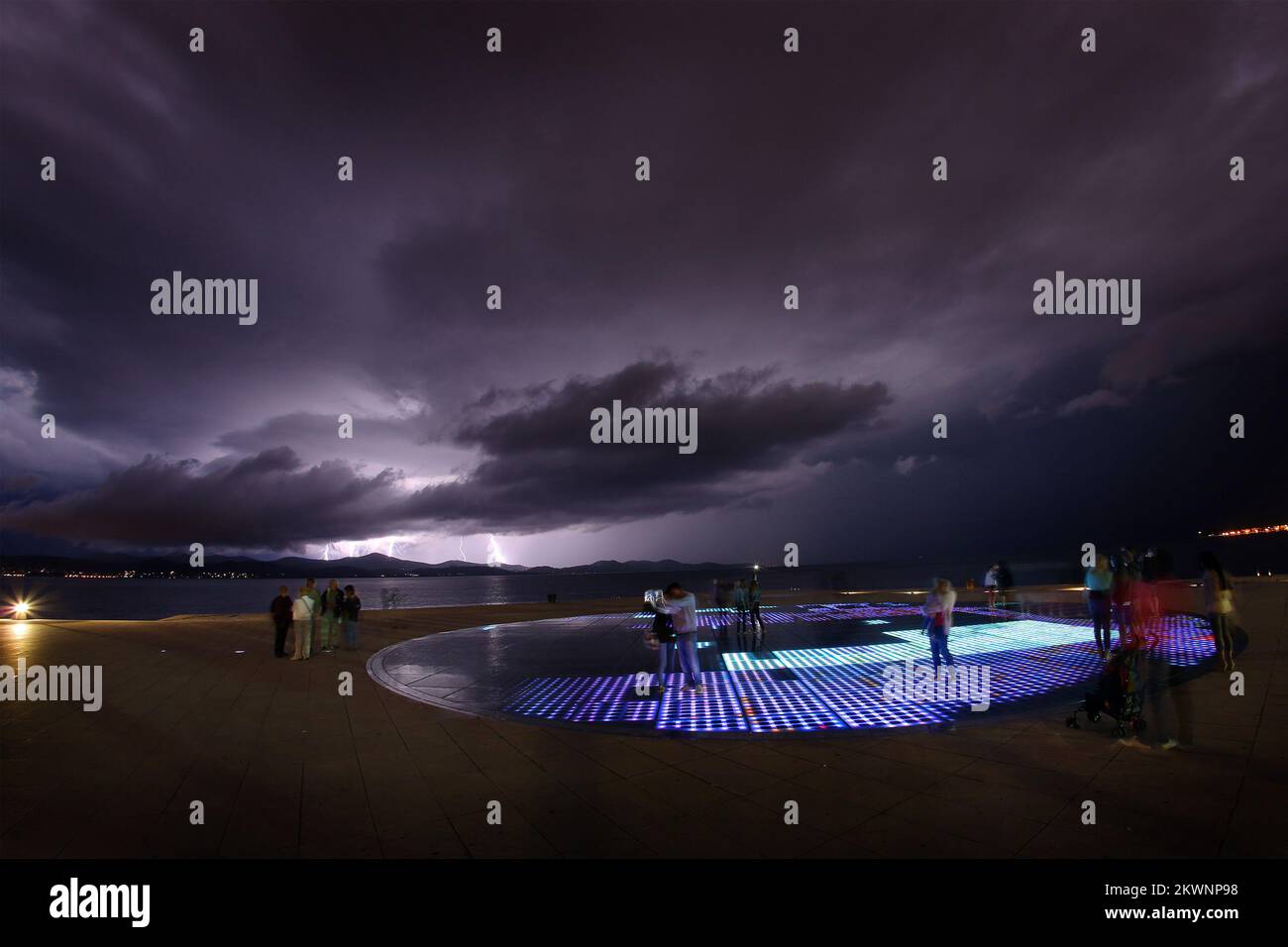 11.09.2013., Zadar, Kroatien - die Stadt Zadar und die Umgebung wurden am zweiten Tag in Folge von einem starken Gewitter getroffen. Bei der Installation, bekannt als Sonnensalutation (Pozdrav Suncu), beobachteten Touristen, wie die Lichter den Himmel über der Insel Ugljan erhellen. Foto: Filip Brala/PIXSELL Stockfoto