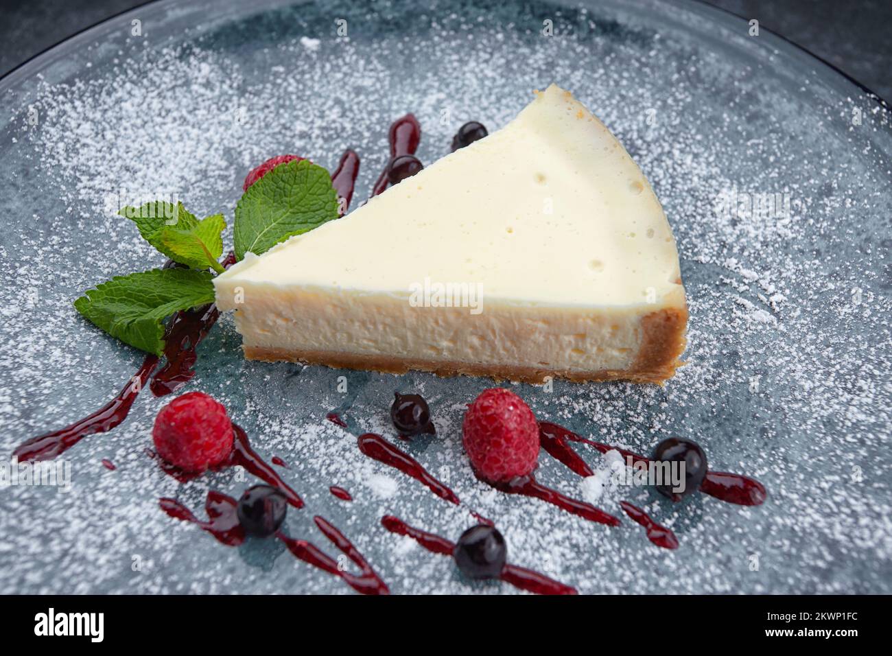 Ein Stück Käsekuchen mit Beeren und Minze Stockfoto
