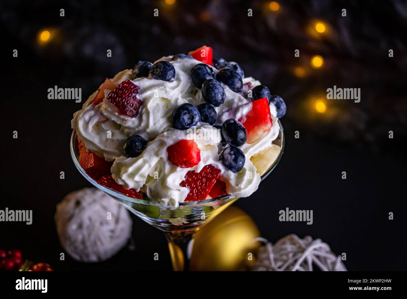 Obstsalat in einem wunderschönen Glas, dekoriert mit Creme Stockfoto