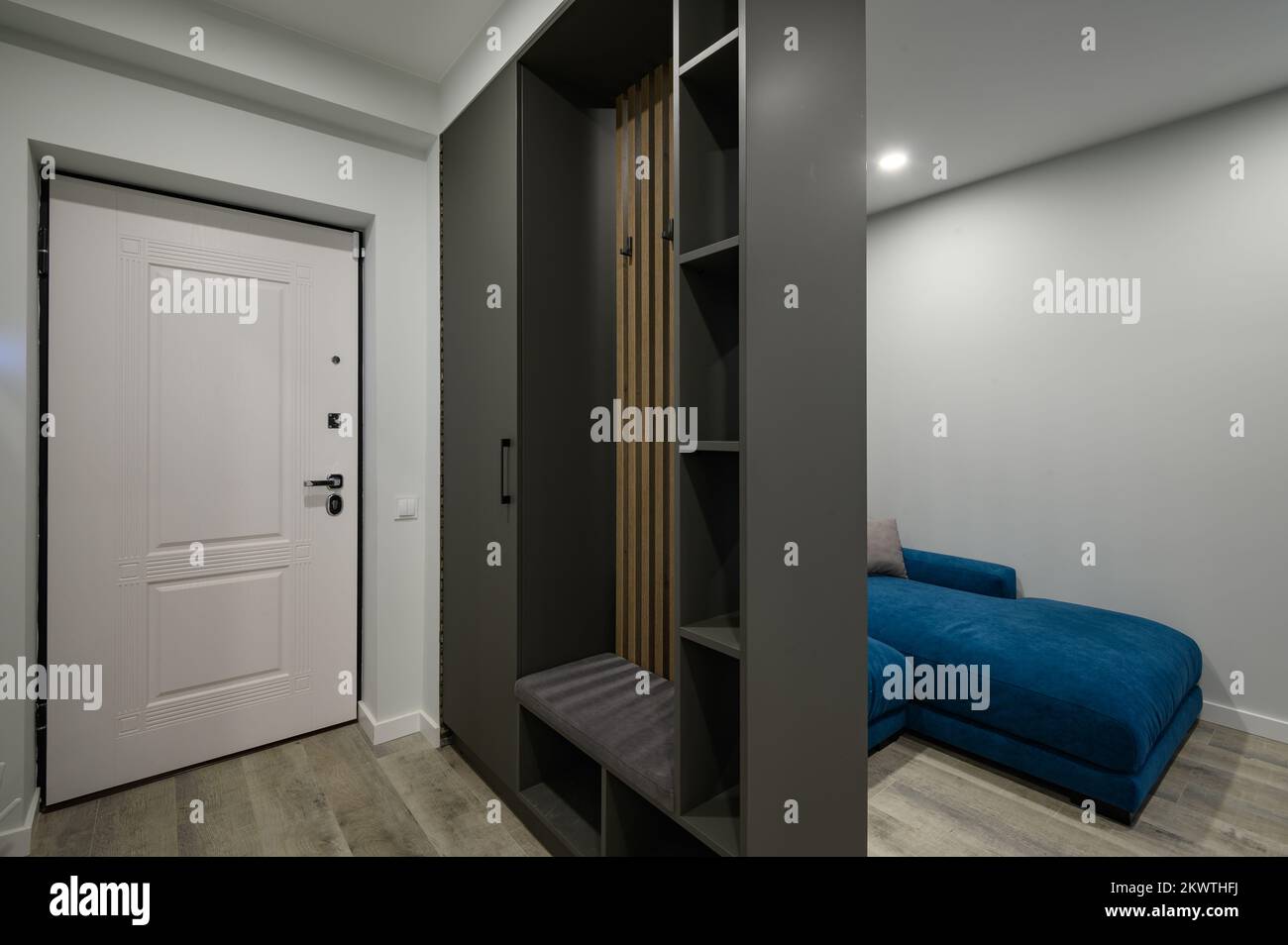 Die Eingangshalle ist an ein kleines modernes Wohnzimmer angeschlossen Stockfoto