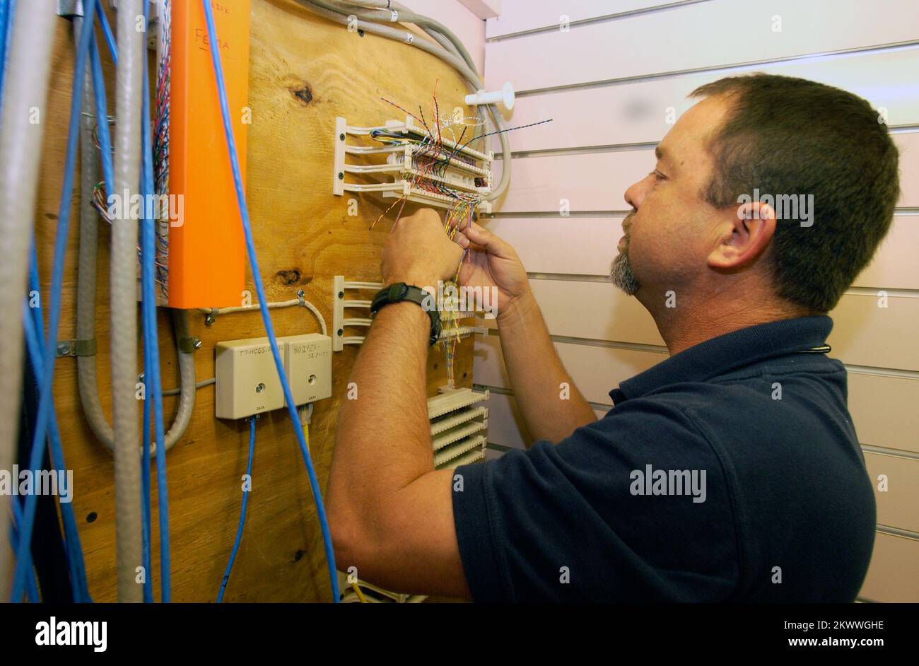 Severe Storms and Tornadoes, Jackson, TN, 8. April 2006 dieser FEMA-Spezialist für Telekommunikation verkabelt ein leeres Geschäft, um bis zu 150 FEMA-Mitarbeiter aufzunehmen, die bald ankommen werden. Das Gemeinsame Feldbüro (Joint Field Office, JFO) wird eingerichtet, um die Tornado-Streikgebiete in Tennessee zu unterstützen. Leif Skoogfors/FEMA. Fotos zu Katastrophen- und Notfallmanagementprogrammen, Aktivitäten und Beamten Stockfoto