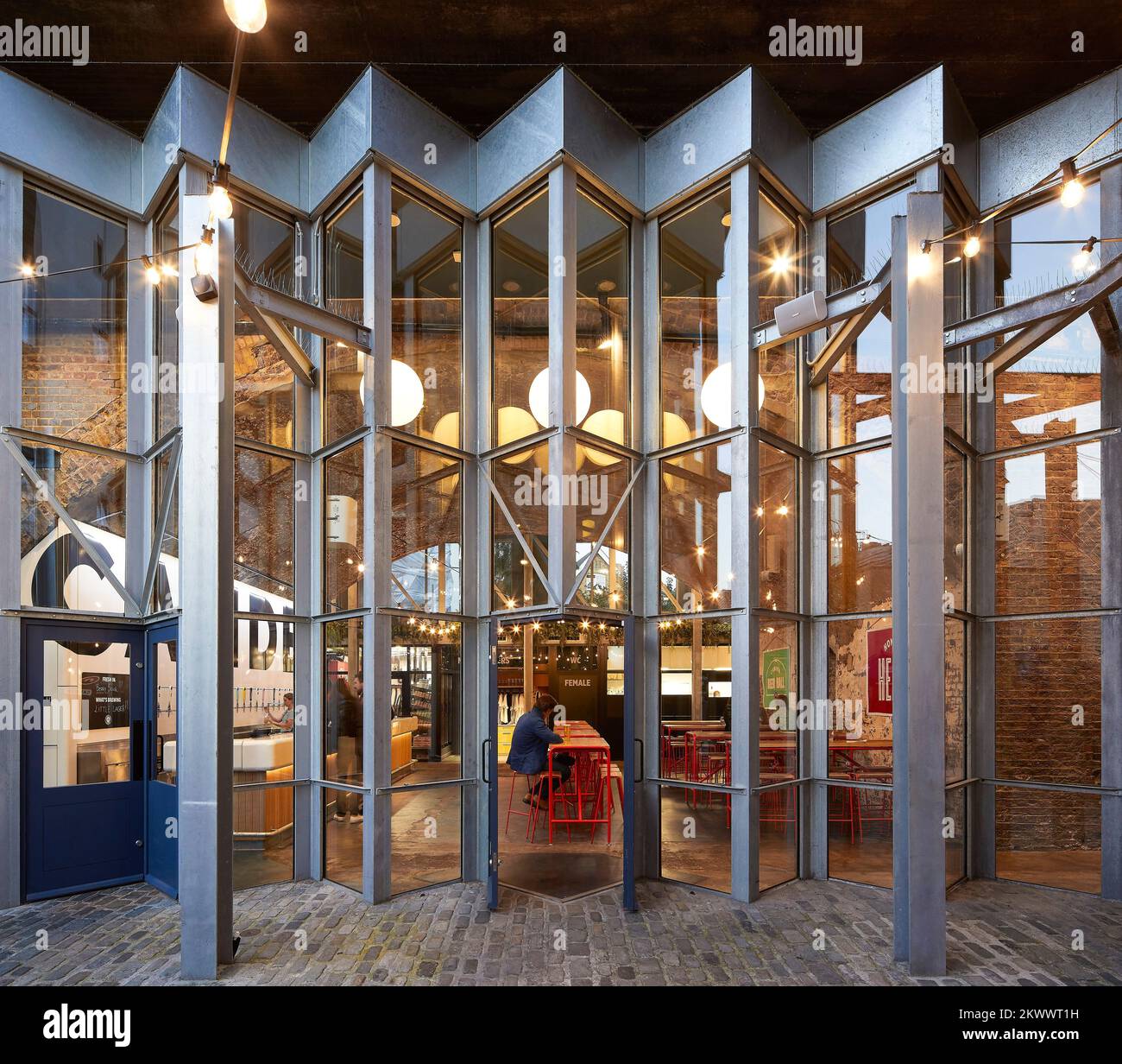 Concertina-Fassade mit Eingang zur Bierhalle. Camden Town Beer Hall, London, Großbritannien. Architekt: Gundry & Ducker, 2021. Stockfoto