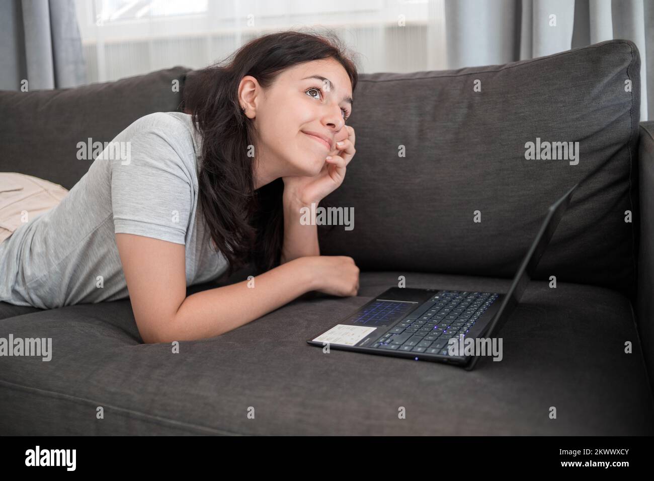 Junge Teenager, die online mit Freunden auf einem Laptop chattet Stockfoto