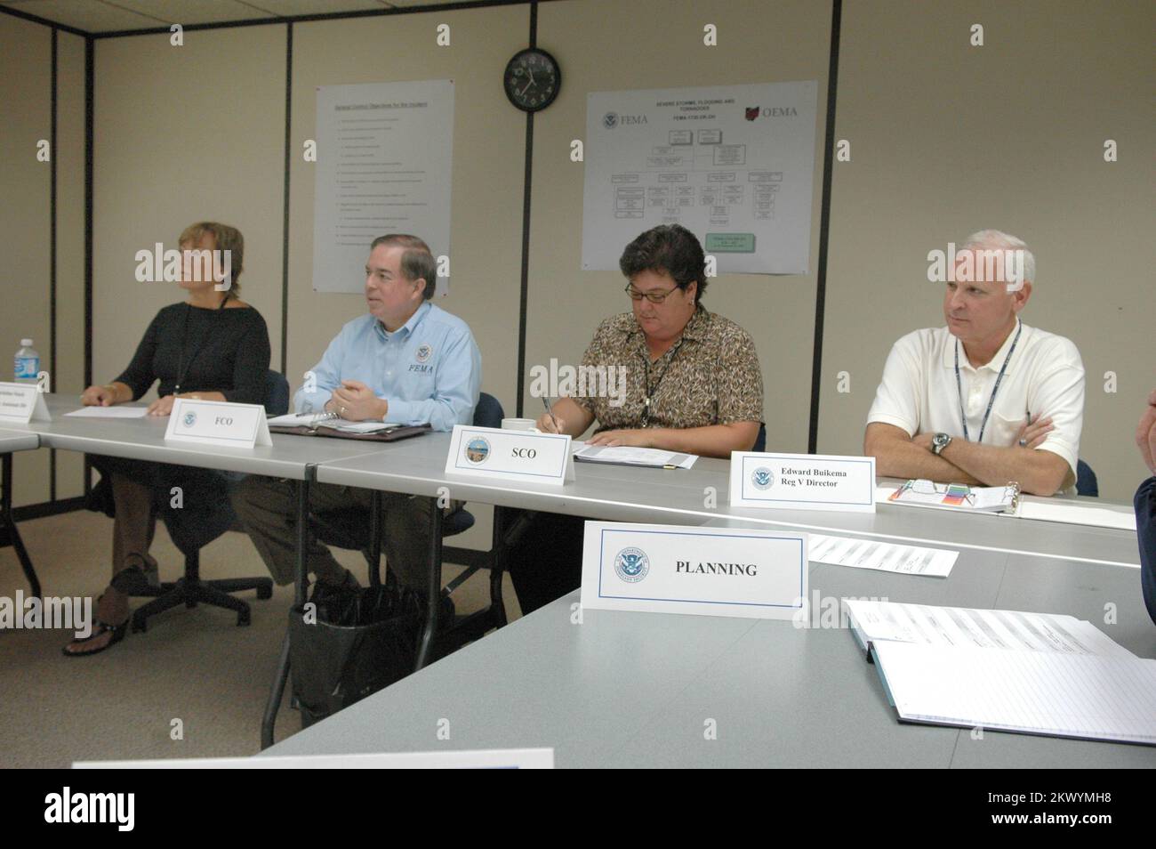 Schwere Stürme, Überschwemmungen und Tornados, Findlay, Ohio, 5. September 2007 FEMA Region 5 Administrator Edward Buikema (rechts) tritt FCO Jesse Munoz (Mitte links) bei der Sitzung der FCO im Joint Field Office (JFO) bei. Der FCO hält regelmäßige Besprechungen mit seinen Mitarbeitern ab, um über den Wiederherstellungsprozess auf dem Laufenden zu bleiben. Mark Wolfe/FEMA.. Fotos zu Katastrophen- und Notfallmanagementprogrammen, Aktivitäten und Beamten Stockfoto