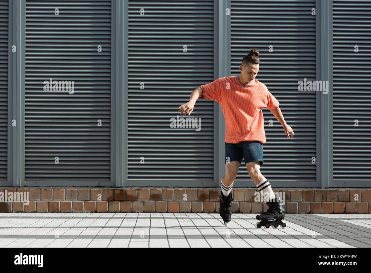 Rollschuhläufer in Kniestrümpfen und Shorts Schlittschuhlaufen auf der Straße, Stockbild Stockfoto