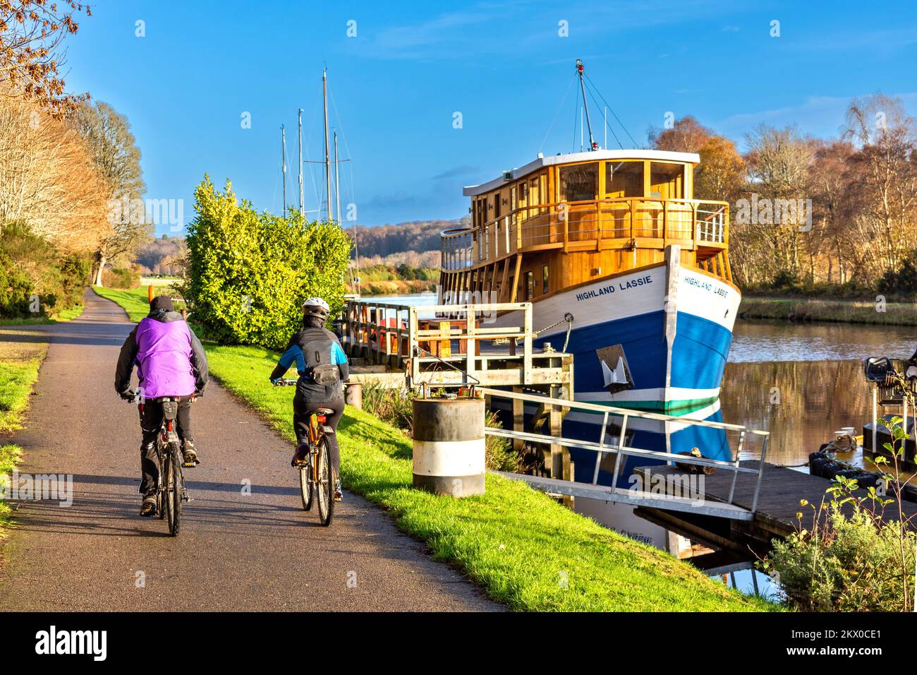 Caledonian Canal Dochgarroch Inverness Herbstradrundfahrt mit Radfahrern, die am Restaurantschiff Highland Lassie vorbeifahren Stockfoto