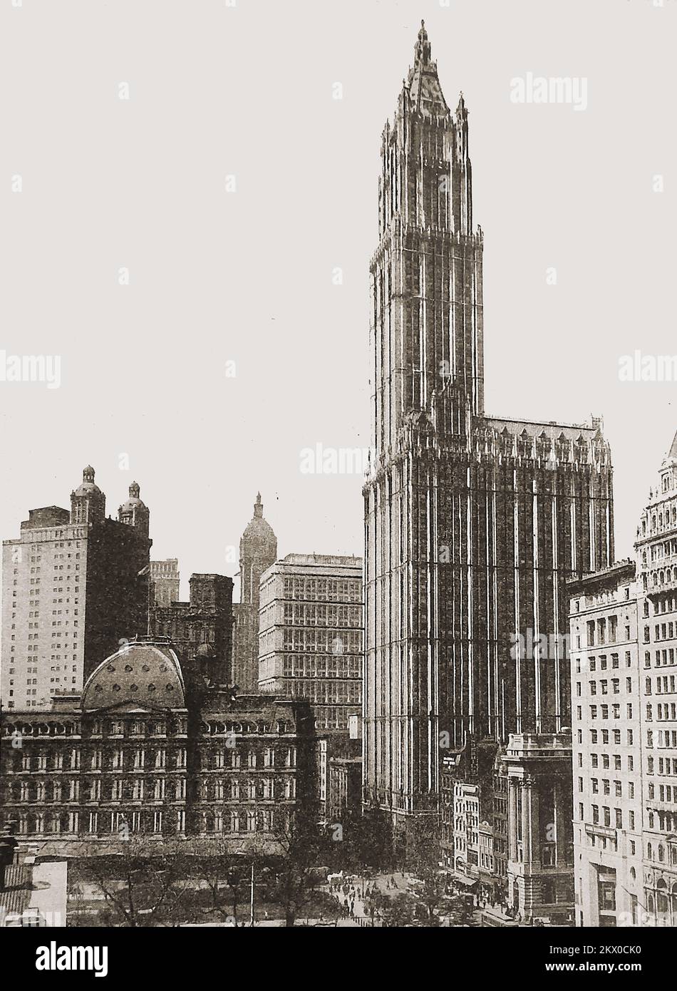 New Yorker Straßenszene aus den 40er Jahren mit dem majestätischen Woolworth Building, entworfen vom Architekten Cass Gilbert. Seine Lage ist der Broadway 233 in Manhattan, New York City. Geplant war es von F. W. Woolworth, dem Gründer der Handelsmarke mit demselben Namen wie der Hauptsitz seines Unternehmens. Die Bauarbeiten begannen 1910 und das Gebäude wurde im April 24. 1913 offiziell eröffnet. Stockfoto