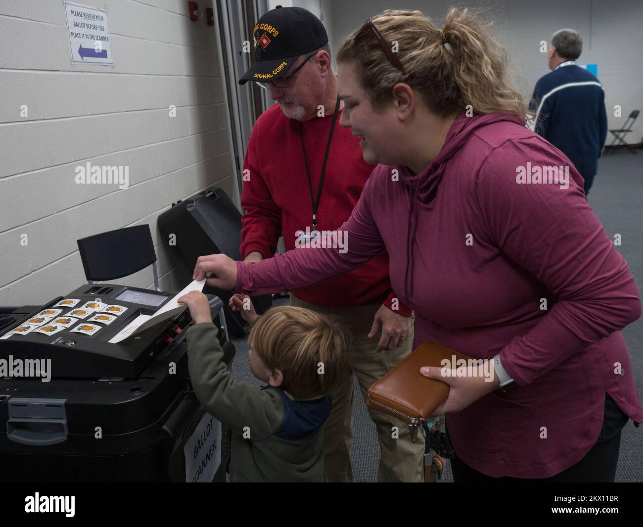 Clarkesville, Georgia, USA. 29.. November 2022. Chandler Franklin, 4 Jahre alt, hilft seiner Mutter Allyson Franklin, ihre Stimmzettel in den Wahlscanner in diesem ländlichen, nordöstlichen Georgia Gemeindezentrum zu stellen. Die Wahlbeteiligung brach Rekorde im ganzen Staat, auch in diesem Bezirk. (Kreditbild: © Sue Dorfman/ZUMA Press Wire) Stockfoto