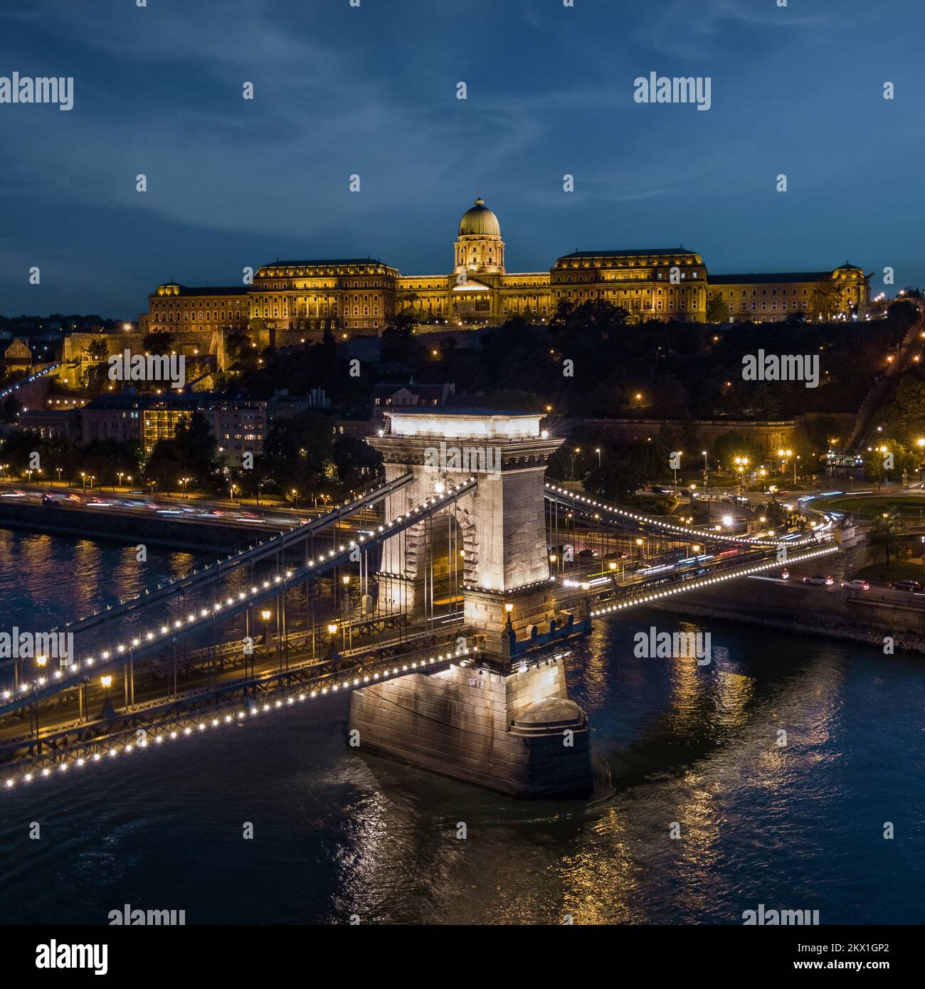 Blick auf den Buda-Palast und die Szechenyi-Kettenbrücke über die Donau bei Abenddämmerung in Budapest, Ungarn. Stockfoto