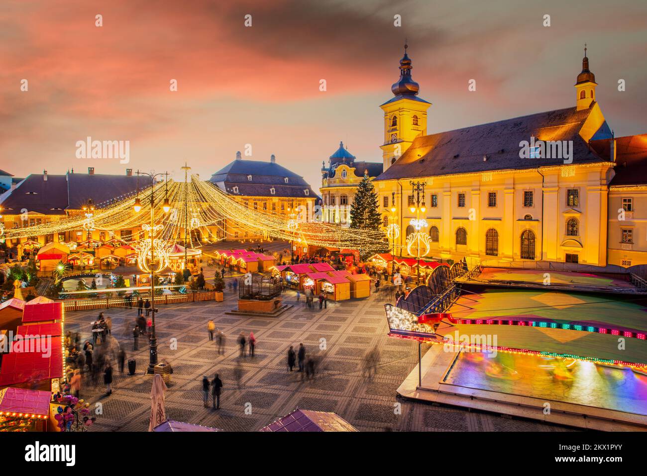 Sibiu, Rumänien - 2014. Dezember: Nachtbild mit Touristen auf dem Sibiu Weihnachtsmarkt auf dem großen Platz, mittelalterliche Innenstadt von Siebenbürgen. Stockfoto