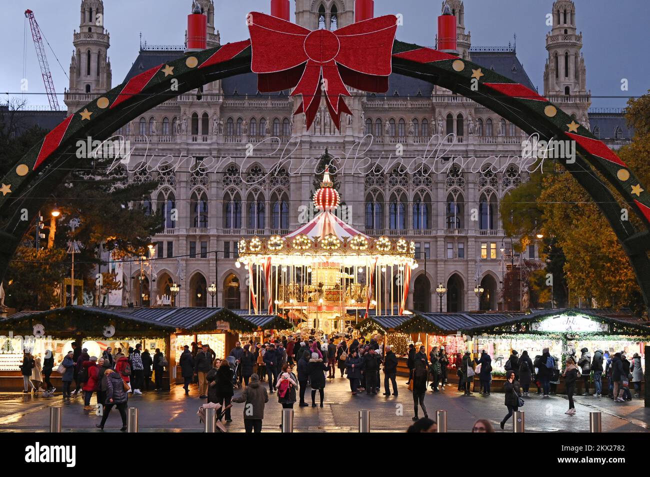 Blick auf den beleuchteten Weihnachtsmarkt vor dem Rathaus in Wien, Österreich; am Abend Stockfoto