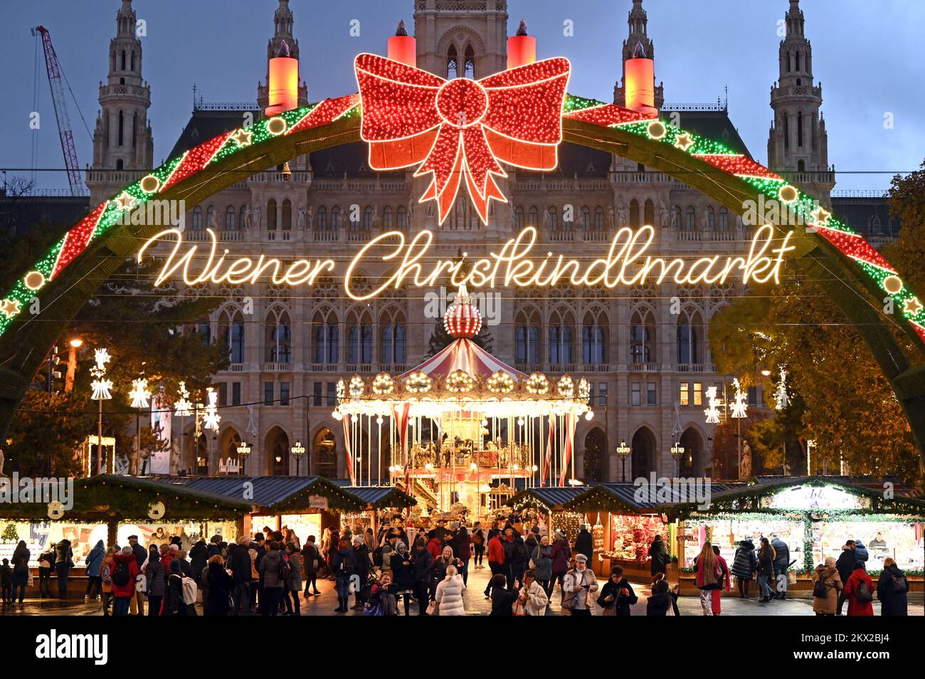 Blick auf den beleuchteten Weihnachtsmarkt vor dem Rathaus in Wien, Österreich; am Abend Stockfoto