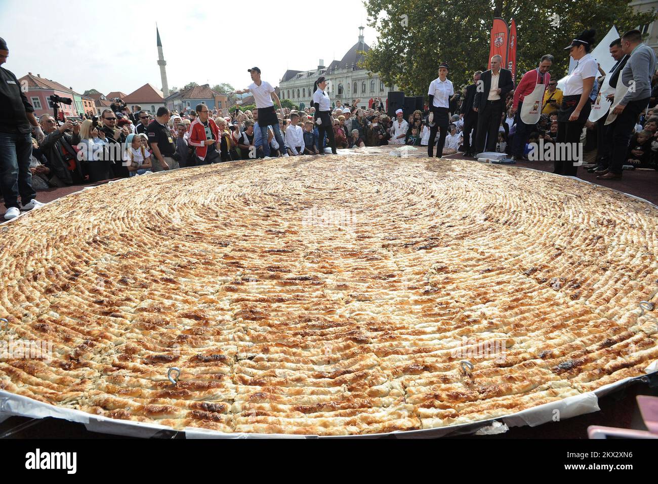 14.10.2017., Tuzla, Bosnien und Herzegowina - Tausende versammelten sich über Nacht in der bosnischen Stadt Tuzla, um einen so großen Burek-Kuchen zu essen, dass die Organisatoren hoffen, dass er einen Weltrekord setzen wird. Der traditionelle Burek-Kuchen ist ein herzhaftes Gericht aus Fleisch, Käse oder Gemüse, bedeckt mit Filo-Gebäck. Es ist das häufigste Essen, das in Häusern und kleinen Restaurants im Balkanland gegessen wird. Der Fleischkuchen, der am Samstag gegessen wurde, wurde von einer örtlichen Bäckerei hergestellt und wiegt 675 Kilogramm. Es wurden etwa 1.500 Blatt Filo-Gebäck verwendet, um es zuzubereiten. Die Messungen des Burek werden an das Guinness-Hauptrekord-Hauptquartier für gesendet Stockfoto 14.10.2017., Tuzla, Bosnien und Herzegowina - Tausende versammelten sich über Nacht in der bosnischen Stadt Tuzla, um einen so großen Burek-Kuchen zu essen, dass die Organisatoren hoffen, dass er einen Weltrekord setzen wird. Der traditionelle Burek-Kuchen ist ein herzhaftes Gericht aus Fleisch, Käse oder Gemüse, bedeckt mit Filo-Gebäck. Es ist das häufigste Essen, das in Häusern und kleinen Restaurants im Balkanland gegessen wird. Der Fleischkuchen, der am Samstag gegessen wurde, wurde von einer örtlichen Bäckerei hergestellt und wiegt 675 Kilogramm. Es wurden etwa 1.500 Blatt Filo-Gebäck verwendet, um es zuzubereiten. Die Messungen des Burek werden an das Guinness-Hauptrekord-Hauptquartier für gesendet Stockfoto