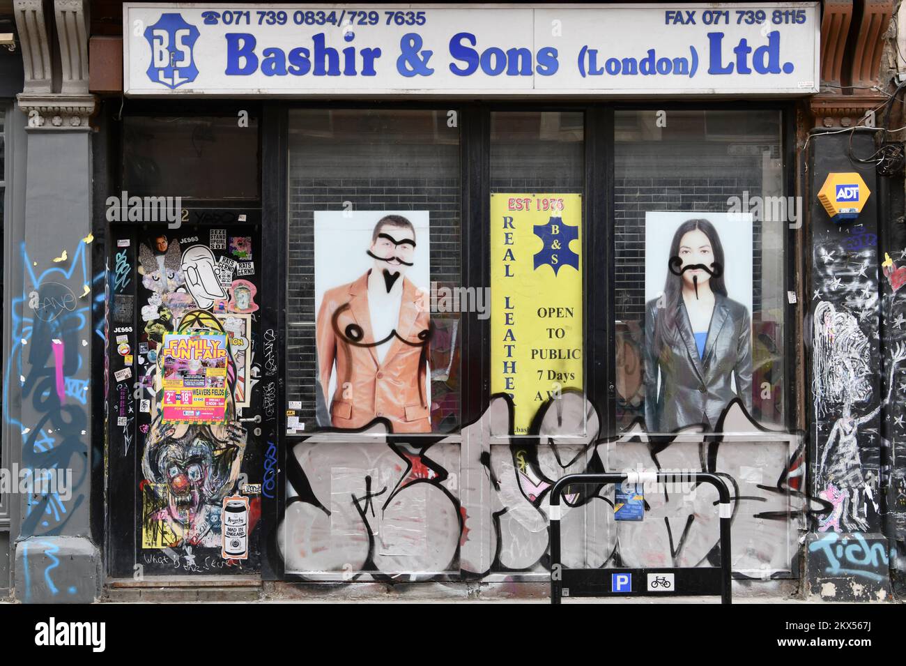 Bashir & Sons Lederladen bedeckt mit Graffiti an der Ecke Brick Lane und Cheshire Street, Shoreditch, London Stockfoto