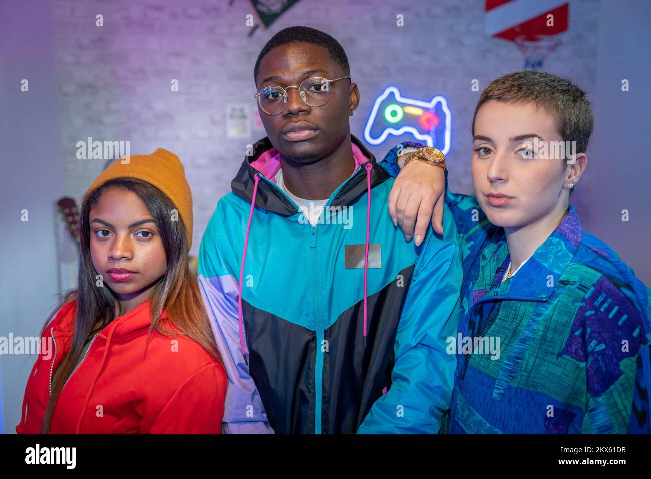 Multiethnische Teenager-Freunde machen Fotos mit ungefiltertem Blitz. Fotoaufnahmen im Nachtleben im Innenbereich. Stockfoto