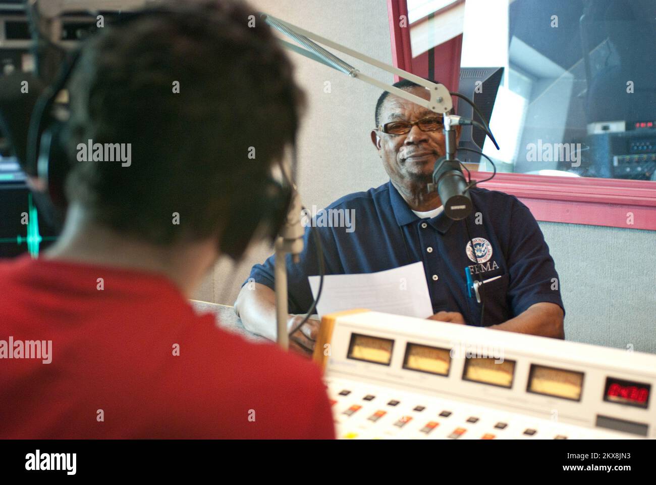 Überschwemmungen - Glassboro, N. J., 4. Mai 2010 Community Relations Specialist Andre Delise hört Anweisungen von Doug Cohen, bevor er eine Übersetzung einer öffentlichen FEMA-Radiosendung in Französisch und Kreolisch aufnimmt. FEMA und Rowan Radio Station arbeiten an diesem mehrsprachigen Ankündigungsprojekt für die betroffenen Einwohner von New Jersey zusammen. Michael Medina-Latorre/FEMA. Schwere Stürme und Überschwemmungen in New Jersey. Fotos zu Katastrophen- und Notfallmanagementprogrammen, Aktivitäten und Beamten Stockfoto