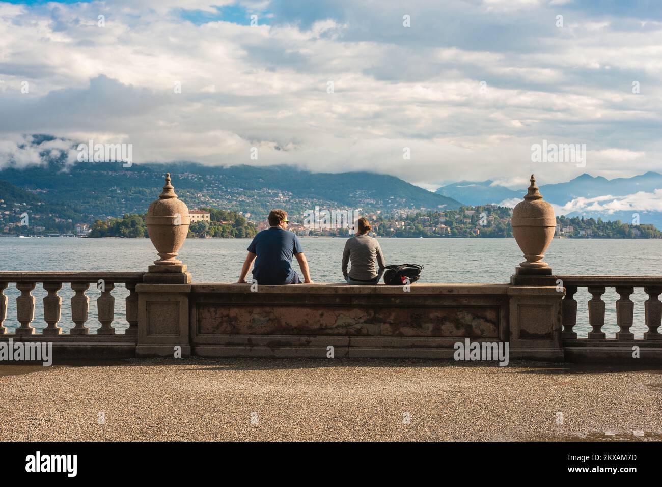 Reisepaar, Rückansicht eines jungen Mannes und einer jungen Frau, die zusammen auf dem Gelände des Palazzo Borromeo, Isola Bella, Lago Maggiore, Italien, Europa sitzen Stockfoto