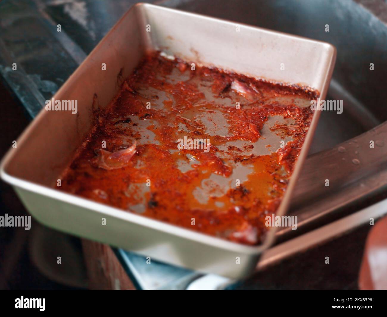 Dreckige, verbrannte Essenspfanne aus Metall auf einem Küchenspül, Innenschließung, flacher freiheitsgrad Stockfoto