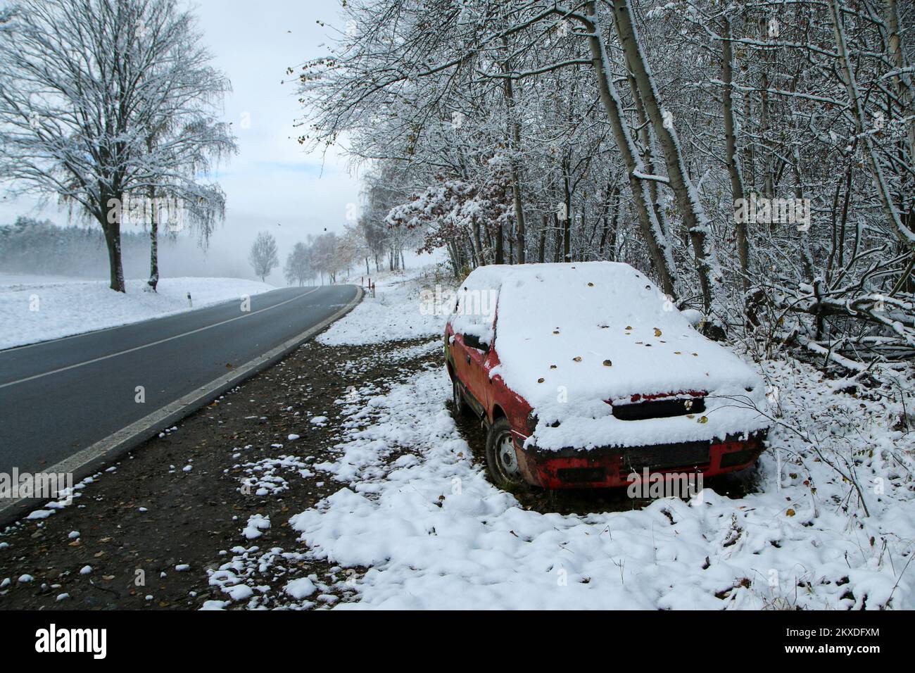 Ein verlassenes Auto, das an der Straße steht. Vielleicht nach dem Verkehrsunfall oder dem Ausfall. Symbolisiert auch die gefährlichen Bedingungen im Winter mit Eis, Schnee und Stockfoto