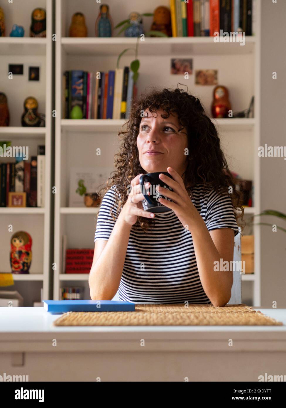 Aufmerksame Spanierin mit einer Tasse Tee oder Kaffee zu Hause Stockfoto