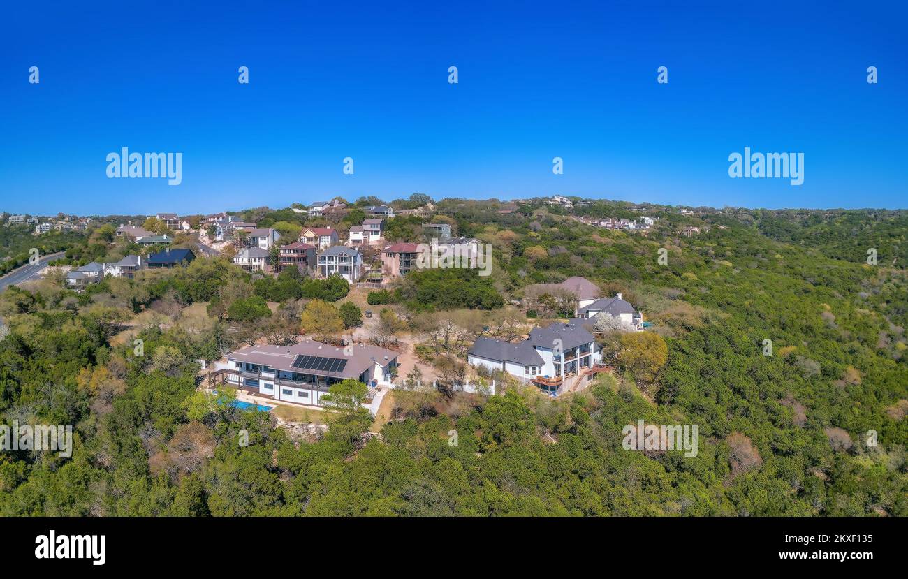 Austin, Texas-Mansions und Villen auf einem Berg aus der Vogelperspektive. Reiche Nachbarschaft inmitten grüner Wälder vor dem Hintergrund des blauen Himmels Stockfoto