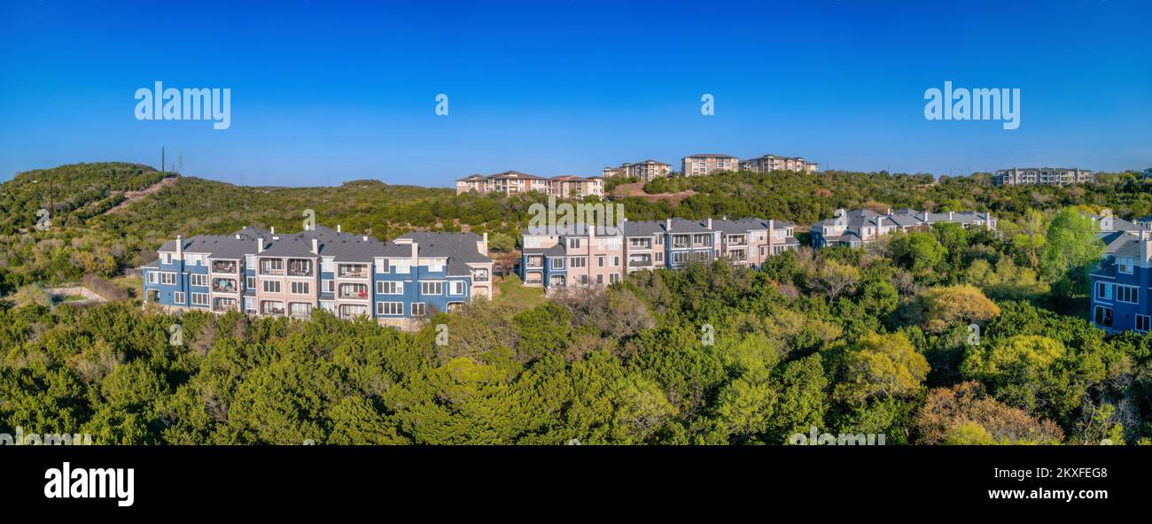 Austin, Texas: Angrenzende Stadthäuser und Wohnhäuser auf einem grünen Hang. Es gibt Stadthäuser an der Vorderseite, nahe dem Rand der Piste und A Stockfoto