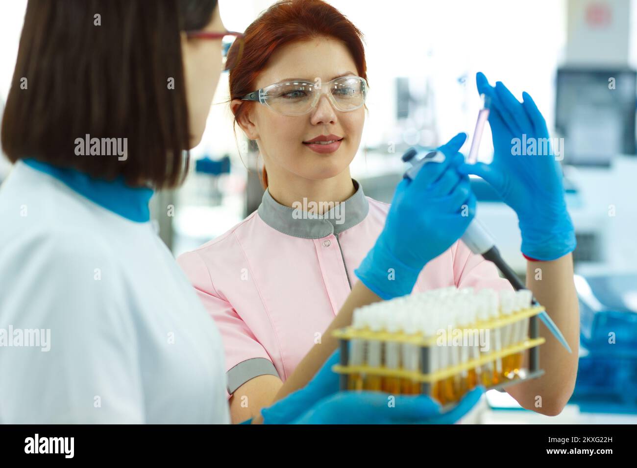 Laborassistenten bei der Beobachtung von Reagenzgläsern in Schutzspektren. Stockfoto