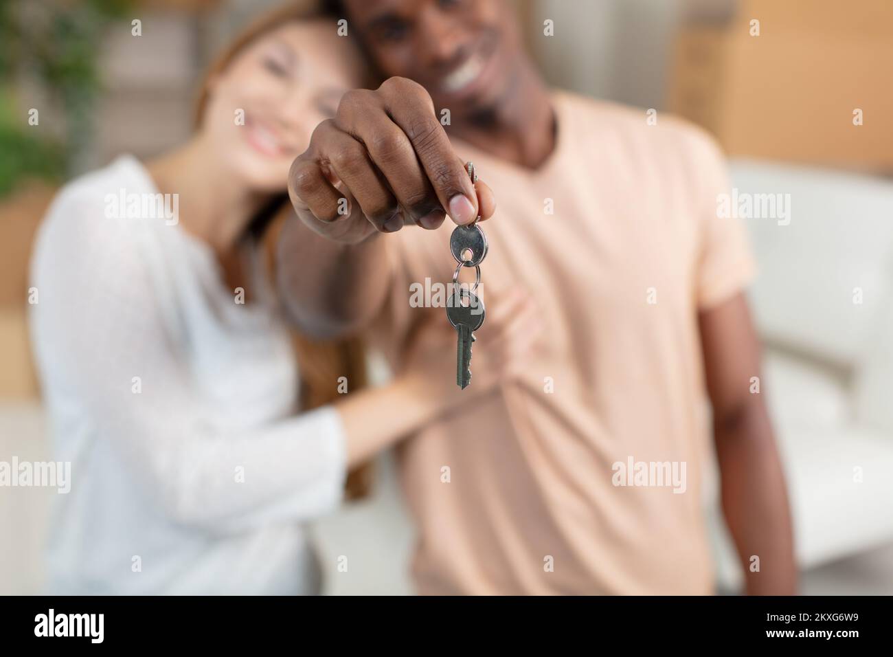 Aufgeregte junge Familie zeigt Schlüssel zu einem Zuhause Stockfoto