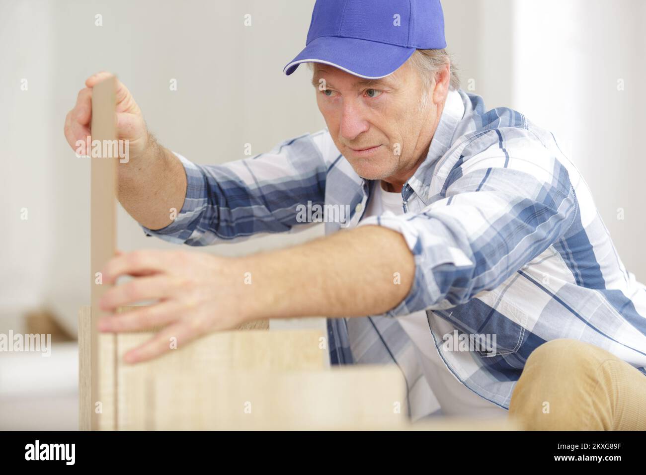 Reifer Mann, der Möbel in einem neuen Zuhause zusammenführt Stockfoto