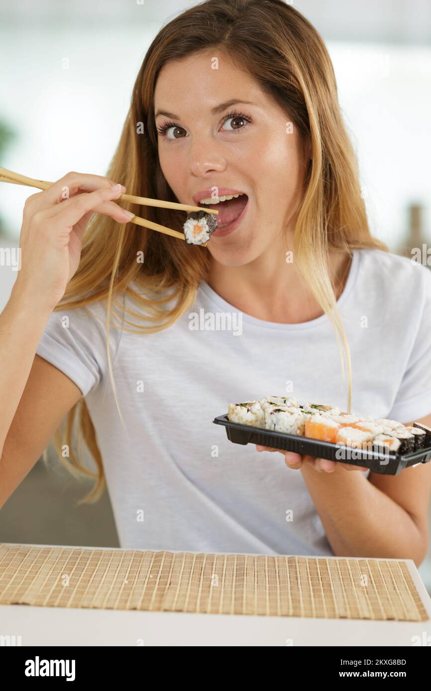 Eine junge Frau, die Sushi isst Stockfoto