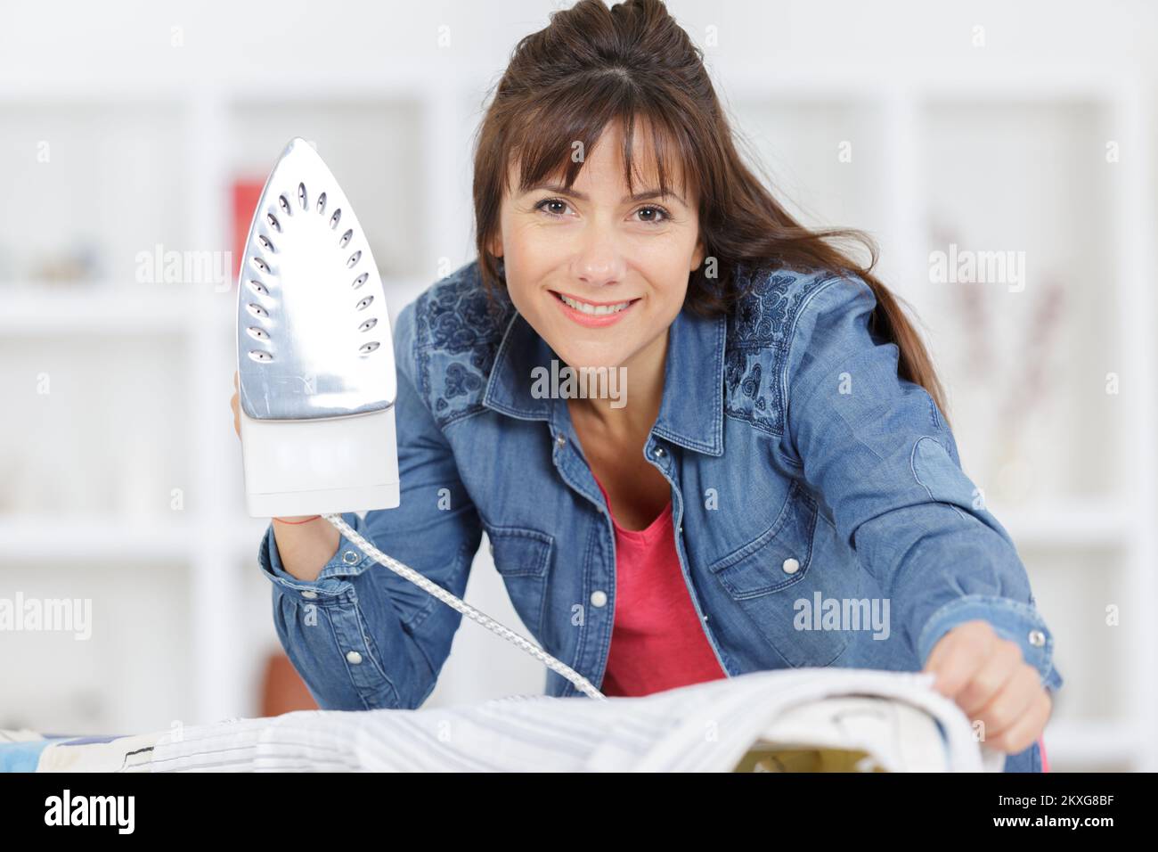 Eine glückliche Frau, die bügelt Stockfoto