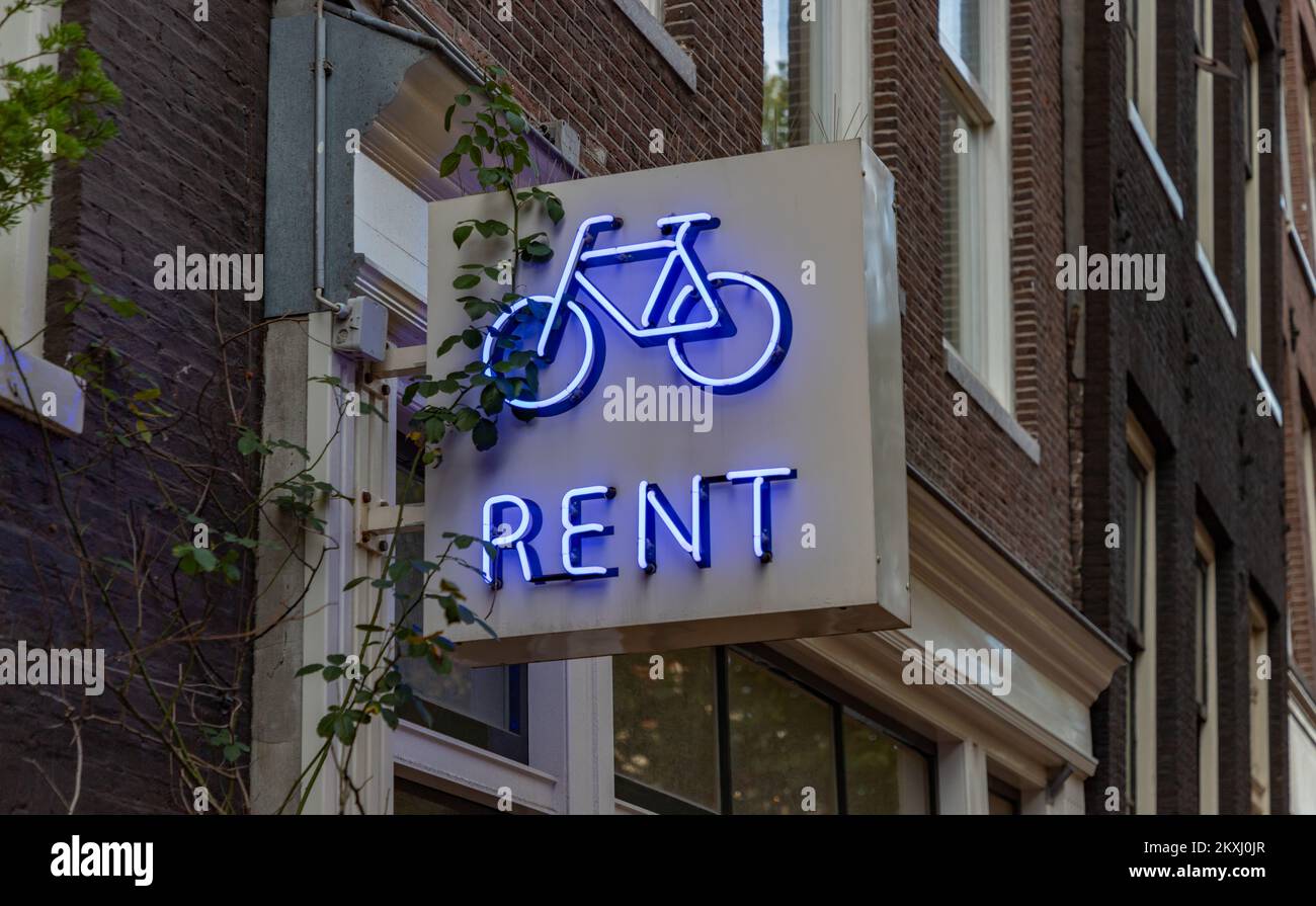 Ein Bild eines Fahrradverleihs mit Neonschild in Amsterdam. Stockfoto