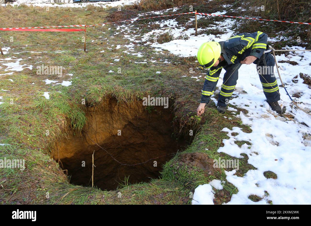 Wie aus den Bildern ersichtlich, öffnete sich ein großes Loch im Boden. Im Dorf Bukovlje in der Gemeinde Generalski Stol fanden sie ein Loch im Boden etwa hundert Meter vom Haus entfernt. Ivan FuduriÄ‡ und Davor KrivaÄiÄ‡ von DVD Bukovlje haben heute eine Tiefe von 17 Metern gemessen. Die Öffnung ist 1,5 bis 2 Meter breit. Aufgrund der Gefahr eines weiteren Einsturzes wurde der Raum abgezäunt, und die zuständigen Behörden wurden gerufen, um die Ursache für die Öffnung des Lochs im Boden zu untersuchen. In Bukovlje, Kroatien, am 04. Februar 2021. Foto: Kristina Stedul Fabac/PIXSELL Stockfoto