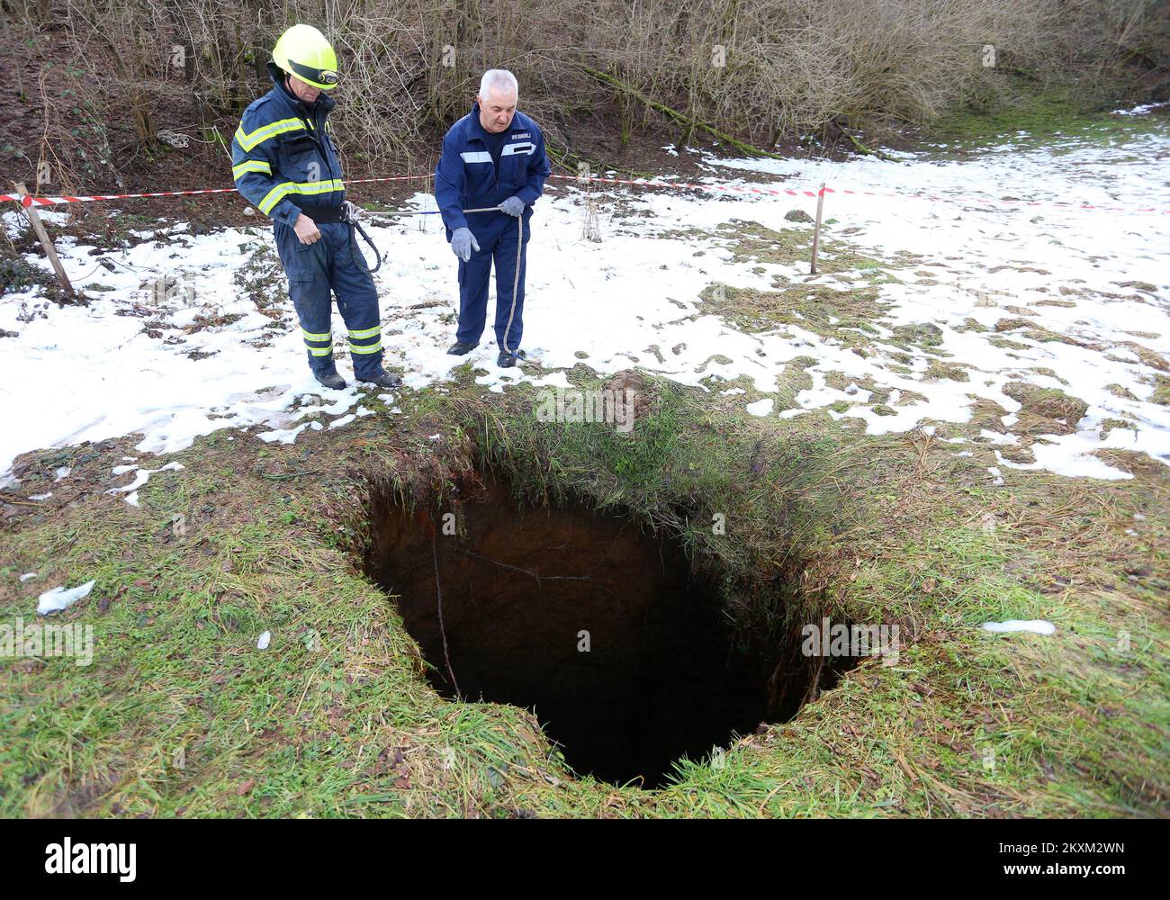 Wie aus den Bildern ersichtlich, öffnete sich ein großes Loch im Boden. Im Dorf Bukovlje in der Gemeinde Generalski Stol fanden sie ein Loch im Boden etwa hundert Meter vom Haus entfernt. Ivan FuduriÄ‡ und Davor KrivaÄiÄ‡ von DVD Bukovlje haben heute eine Tiefe von 17 Metern gemessen. Die Öffnung ist 1,5 bis 2 Meter breit. Aufgrund der Gefahr eines weiteren Einsturzes wurde der Raum abgezäunt, und die zuständigen Behörden wurden gerufen, um die Ursache für die Öffnung des Lochs im Boden zu untersuchen. In Bukovlje, Kroatien, am 04. Februar 2021. Foto: Kristina Stedul Fabac/PIXSELL Stockfoto