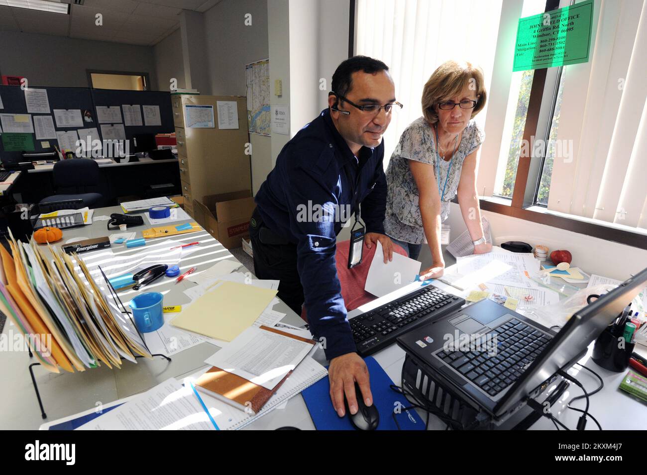 Hurrikan/Tropical Storm - Windsor, Verb , 27. September 2011 FEMA Joint Field Office IT Network Manager, Left, unterstützt FEMA JFO, Leiter der Abteilung Abwehr, Cheryl Ramsey mit ihrem Computer im Joint Field Office. Windsor, CT, 27. September 2011--FEMA Joint Field Office IT Network Manager, Left, hilft FEMA JFO, Mitigation Branch Director, Cheryl Ramsey mit ihrem Computer im Joint Field Office. Fotos zu Katastrophen- und Notfallmanagementprogrammen, Aktivitäten und Beamten Stockfoto