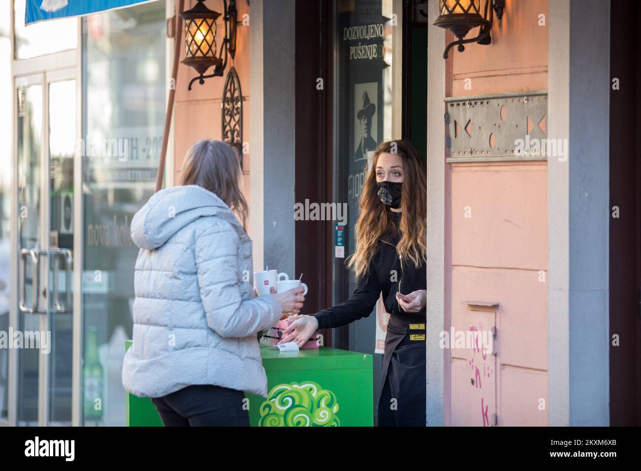 Eine Frau kauft Kaffee in der Café-Bar, da die Beschränkungen der Coronavirus-Krankheit (COVID-19) gelockert werden, sodass Menschen in Fitnessstudios trainieren, Sprachschulen eröffnen, Wettgeschäfte eröffnen und Kaffee zum Mitnehmen nehmen nehmen können, am 15. Februar 2021 in Rijeka, Kroatien. Foto: Nel Pavletic/PIXSELL Stockfoto