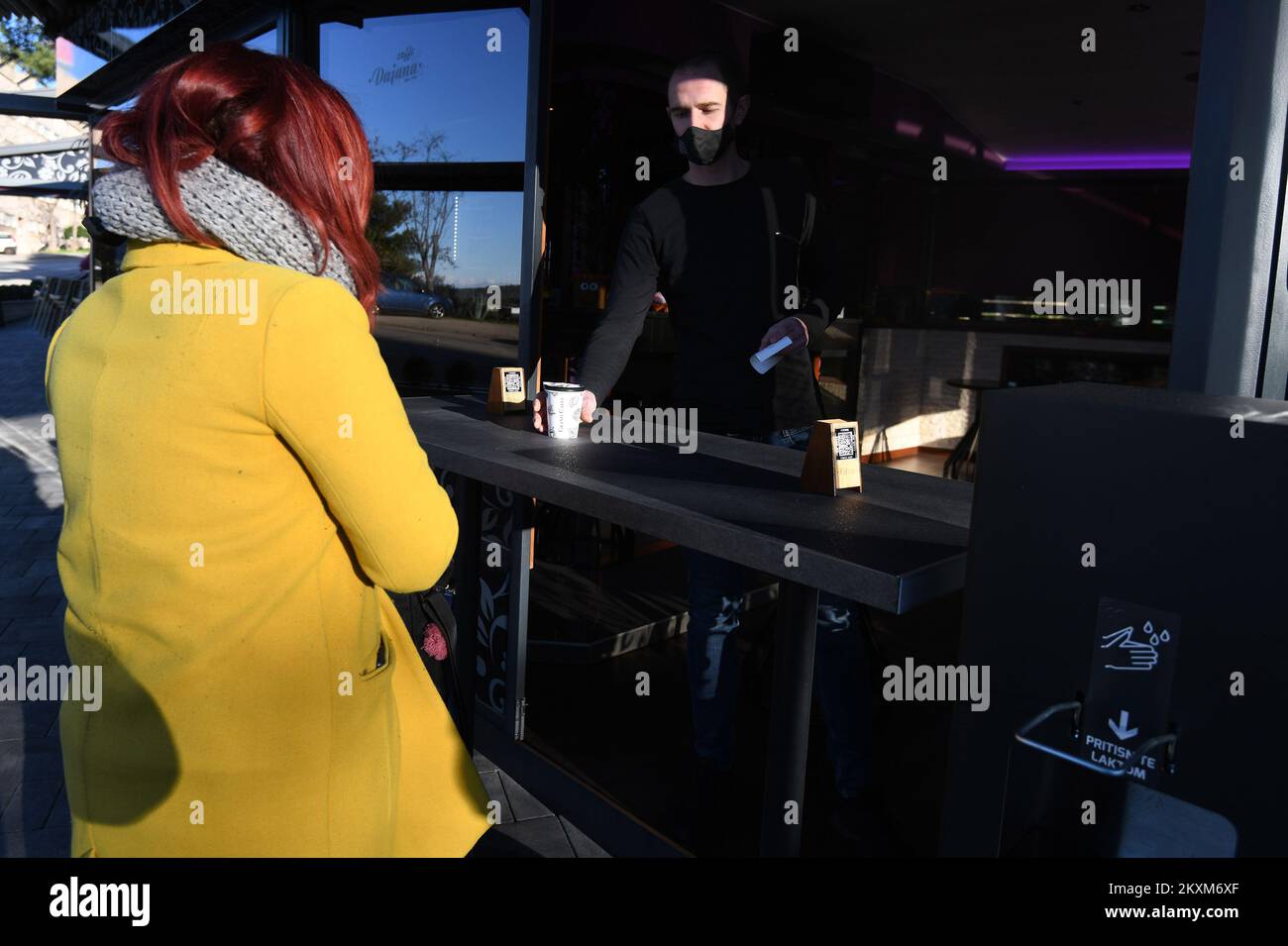 Eine Frau kauft Kaffee in der Café-Bar, da die Beschränkungen der Coronavirus-Krankheit (COVID-19) gelockert werden, so dass Menschen in Fitnessstudios trainieren, Sprachschulen eröffnen, Wettgeschäfte eröffnen und Kaffee zum Mitnehmen nehmen nehmen können, am 15. Februar 2021 in Sibenik, Kroatien. Foto: Hrvoje Jelavic/PIXSELL Stockfoto
