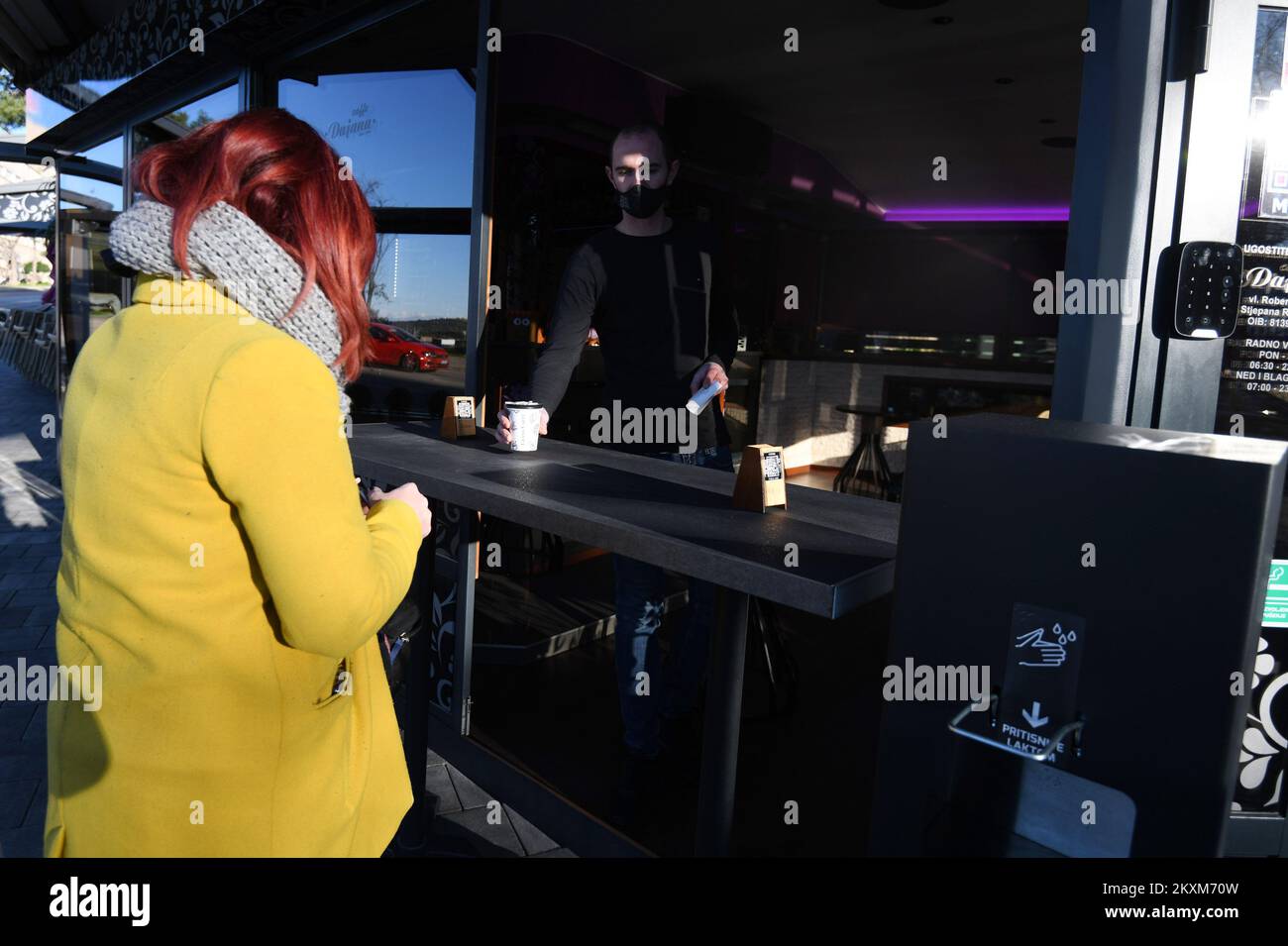 Eine Frau kauft Kaffee in der Café-Bar, da die Beschränkungen der Coronavirus-Krankheit (COVID-19) gelockert werden, so dass Menschen in Fitnessstudios trainieren, Sprachschulen eröffnen, Wettgeschäfte eröffnen und Kaffee zum Mitnehmen nehmen nehmen können, am 15. Februar 2021 in Sibenik, Kroatien. Foto: Hrvoje Jelavic/PIXSELL Stockfoto