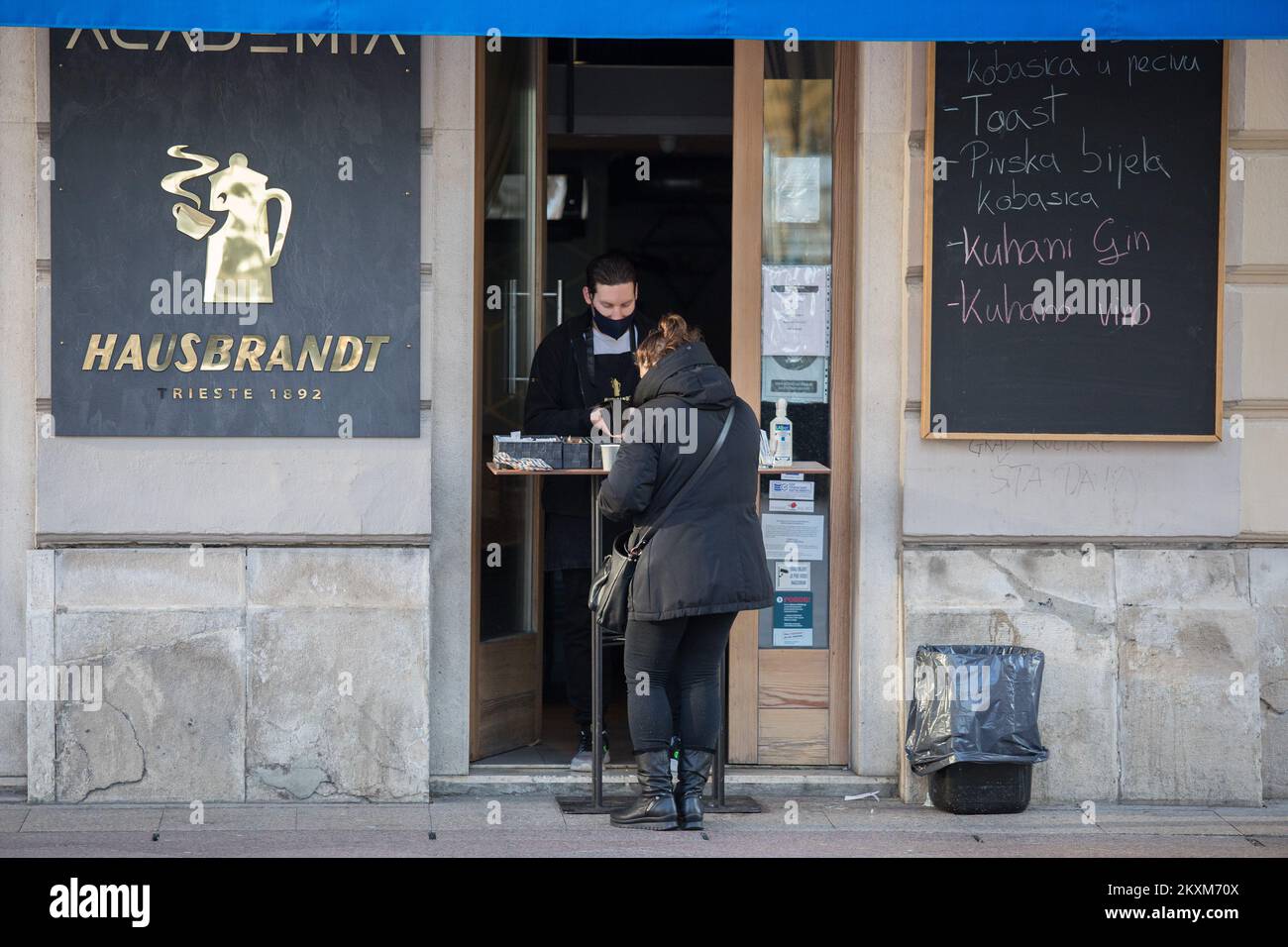 Eine Frau kauft Kaffee in der Café-Bar, da die Beschränkungen der Coronavirus-Krankheit (COVID-19) gelockert werden, sodass Menschen in Fitnessstudios trainieren, Sprachschulen eröffnen, Wettgeschäfte eröffnen und Kaffee zum Mitnehmen nehmen nehmen können, am 15. Februar 2021 in Rijeka, Kroatien. Foto: Nel Pavletic/PIXSELL Stockfoto