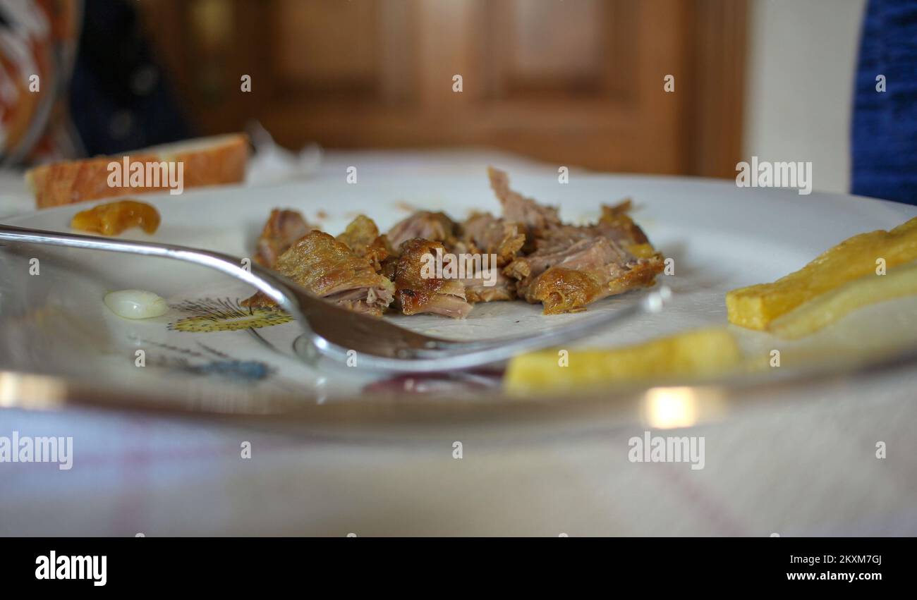Etwas Brot und Pommes und eine Gabel auf dem Teller während des Mittagessens Stockfoto
