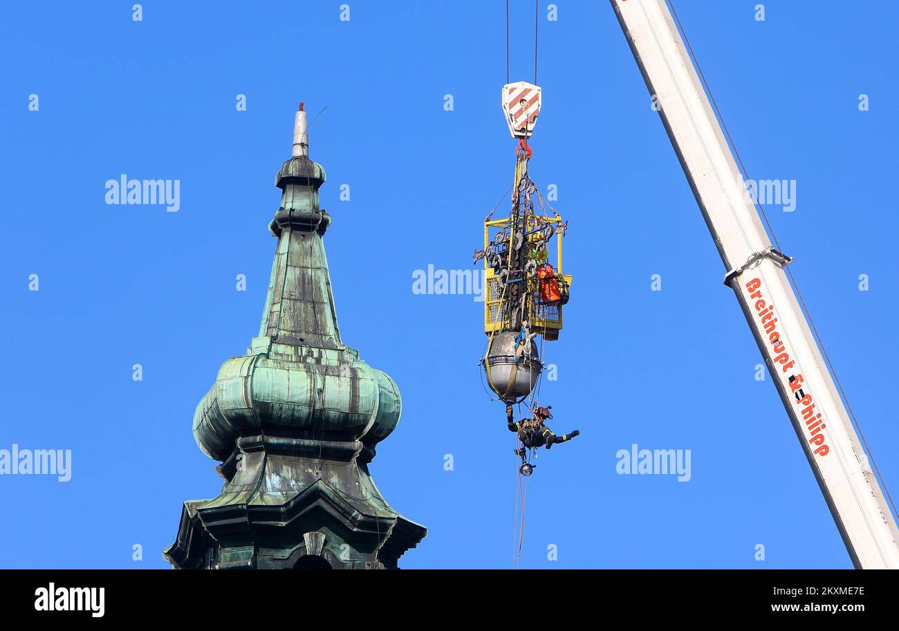 Entfernung von vergoldetem Querbarometer und Äpfeln aus der Kirche der Heiligen Dreifaltigkeit in Karlovac, Kroatien, am 2. März 2021. Aufgrund der Schäden nach dem Erdbeben wurden das Querbarometer und ein Apfel mit einem Gewicht von etwa 400 Kilogramm vom Glockenturm der ältesten Kirche in Karlovac entfernt. Die Krise ist 230 Jahre alt, und Feuerwehrleute haben sich mit Hilfe eines 60-Tonnen-Krans an der Überwindung der Krise beteiligt. Nur einige österreichisch-ungarische Städte hatten ein Kreuzbarometer, und Karlovac war bis heute unter ihnen. Foto: Kristina Stedul Fabac/PIXSELL Stockfoto