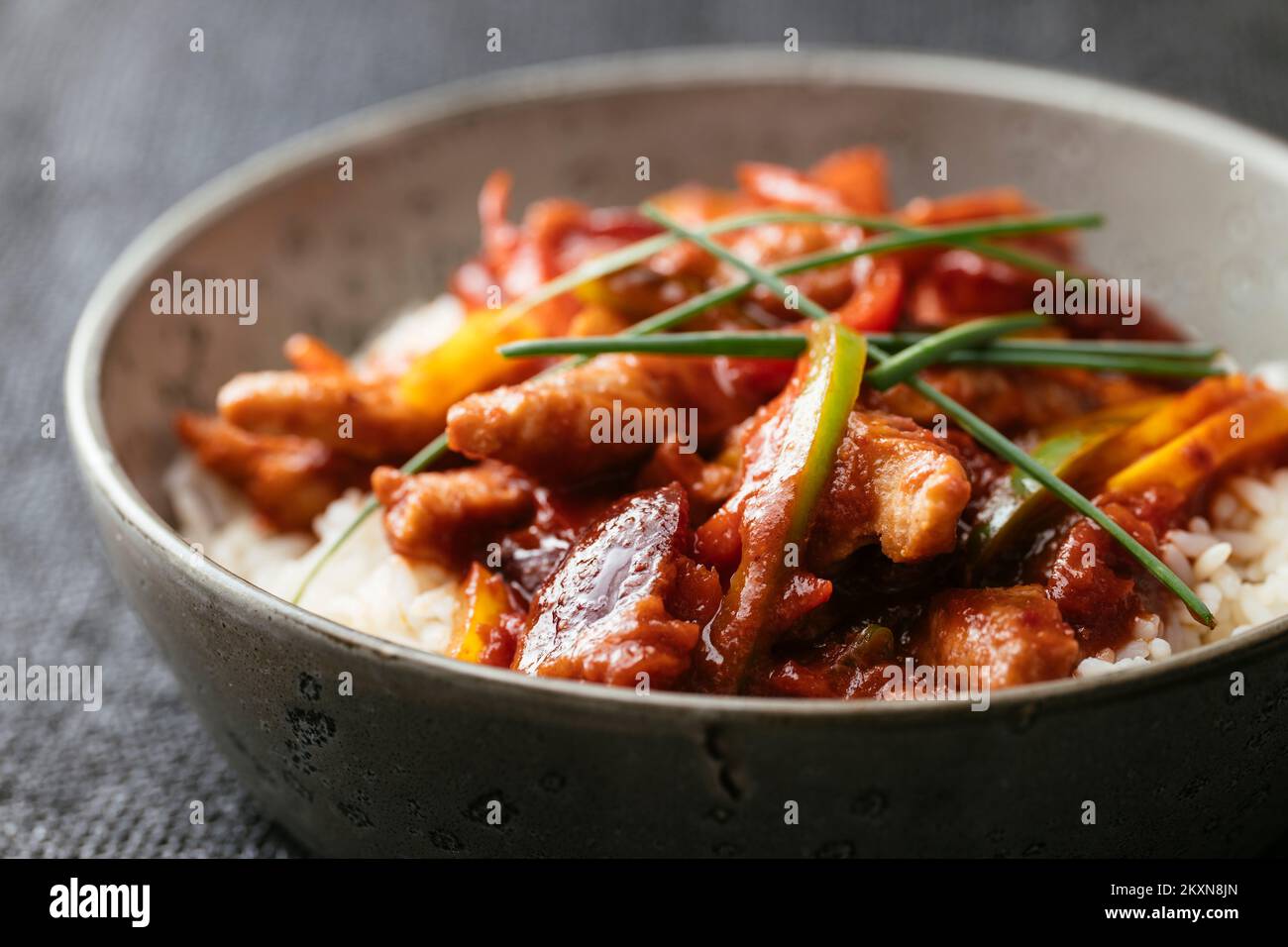 Strukturiertes pflanzliches Protein (TVP) mit einer würzigen chinesischen Pflaumensoße mit Paprika auf Reis. Stockfoto