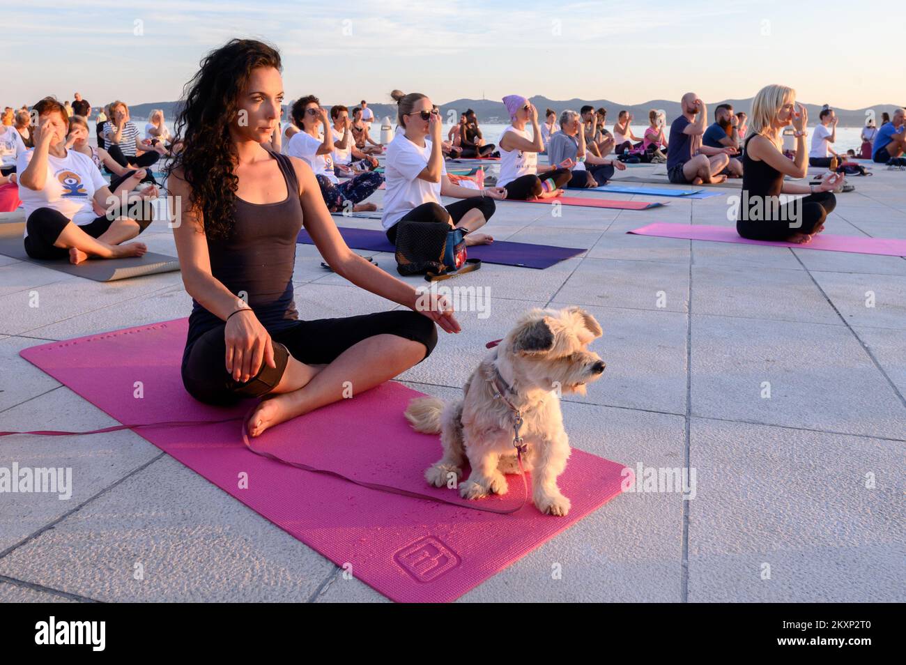 Die Menschen üben Yoga, während die Sonne untergeht am Gruß zur Sonne Monument im Rahmen der Feier des Inernational Yoga Day in Zadar, Kroatien am 17. Juni 2021. Das Denkmal wurde vom kroatischen Architekten Nikola Basic entworfen und symbolisiert die Kommunikation mit der Natur und kommuniziert mit Licht. Foto: Dino Stanin/PIXSELL Stockfoto