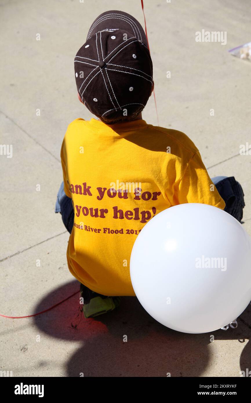 Überschwemmungen - Minot, N. D. , 22. Juni 2012 Ein junger Mann sitzt und schaut sich die Feierlichkeiten bei der Stillegung der Schule Erik Ramstad an. Dieses T-Shirt drückt das Gefühl von Minots „Weekend of Hope“ aus, ein Jahr nachdem die Flut im Souris Valley die Gemeinde verwüstet hat. Robert Kaufmann/FEMA. Überschwemmung In North Dakota. Fotos zu Katastrophen- und Notfallmanagementprogrammen, Aktivitäten und Beamten Stockfoto