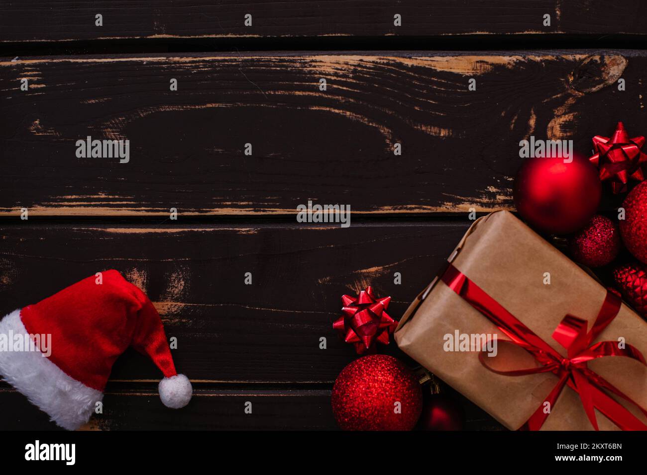 Christmass Flatlay Geschenkbox, Weihnachtsmannmütze und rotes weihnachtsbaumspielzeug auf Holzhintergrund. Stockfoto