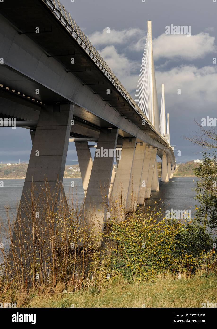 Sehen Sie die Queensferry Crossing Bridge entlang des Ufers über Firth of Forth in der Nähe von Edinburgh, von unterhalb der Brücke in South Queensferry. Stockfoto