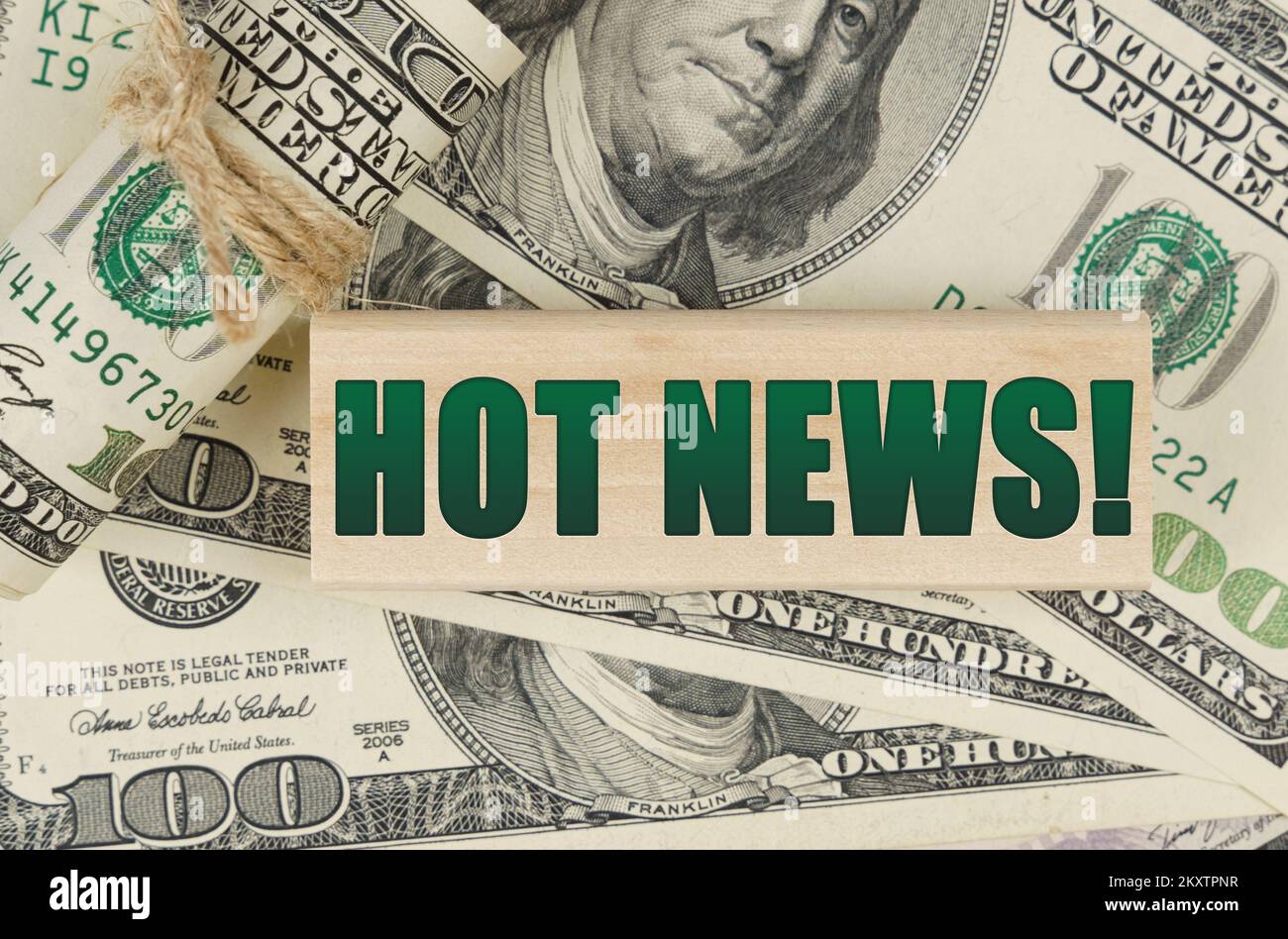Geschäfts- und Finanzkonzept. Auf dem Dollar ist ein Holzteller mit der Inschrift "HOT NEWS" Stockfoto
