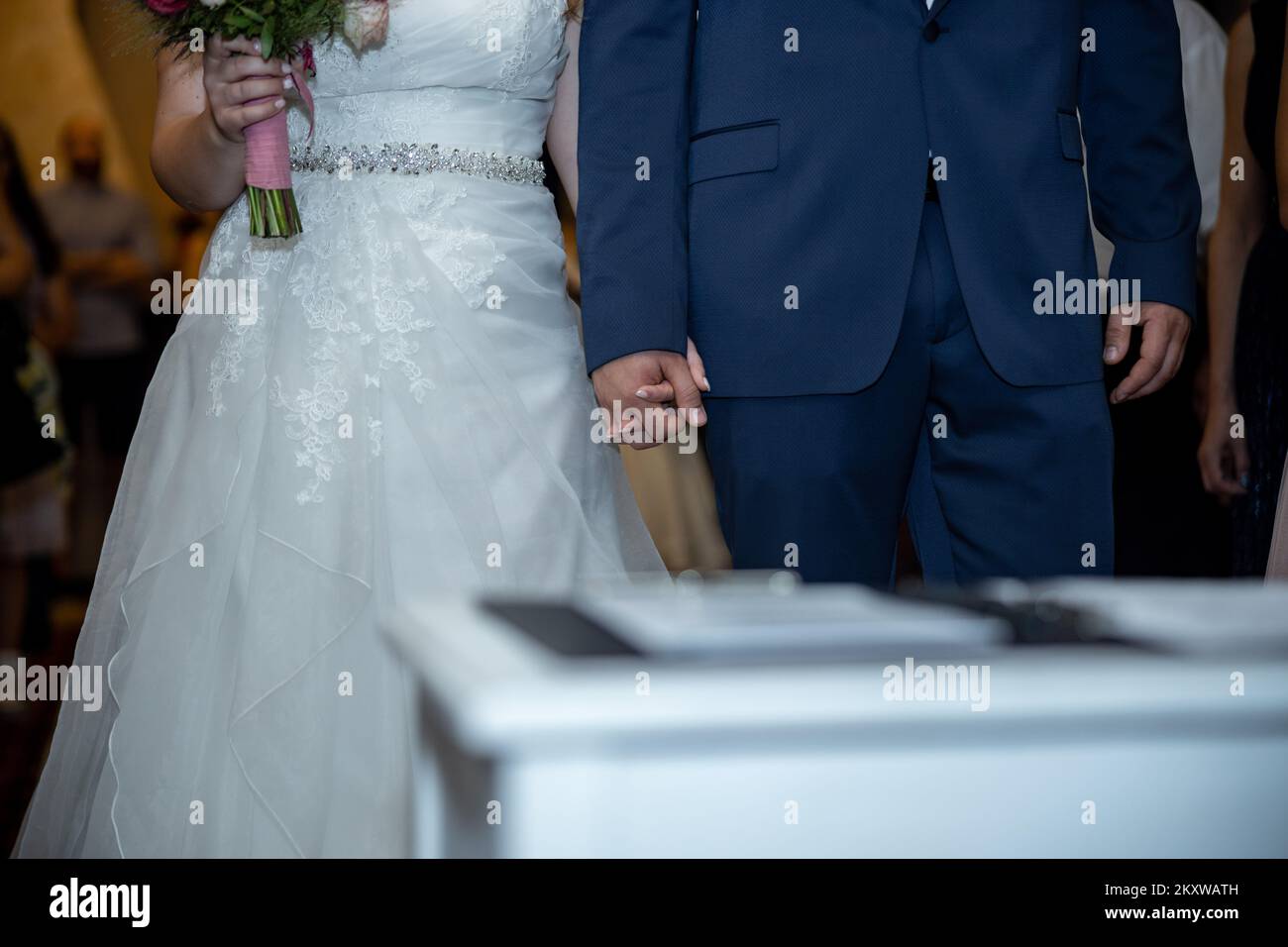 Ein Paar, das am Hochzeitstag im Offizierszimmer Händchen hält. Hochwertiges Foto Stockfoto