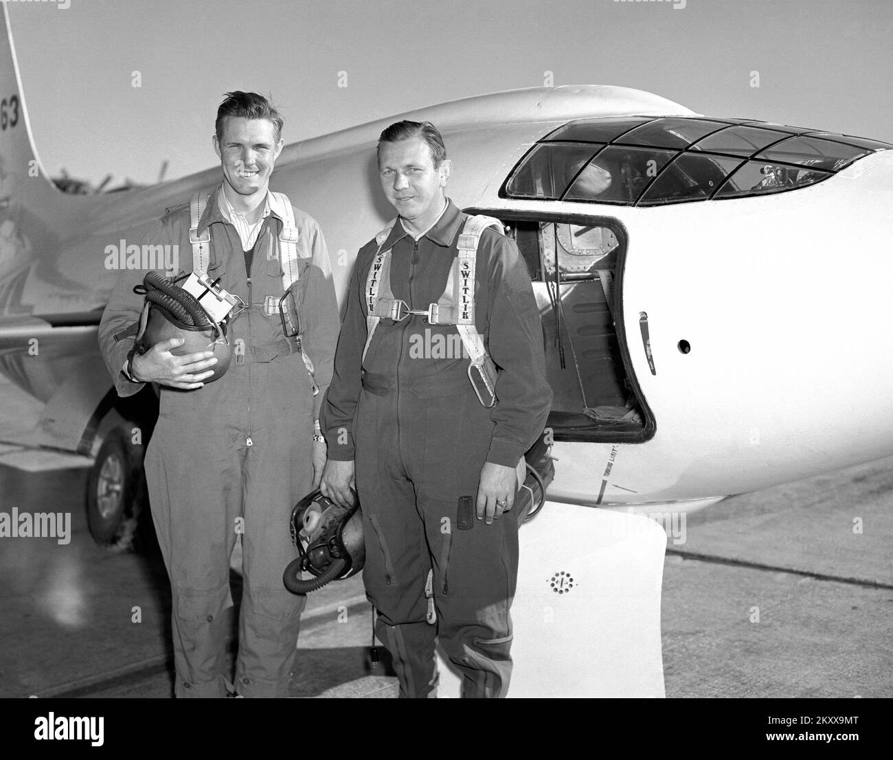 Die Bell Aircraft Corporation X-1-2 und zwei der NACA-Piloten, die das Flugzeug flogen. Der linke ist Robert Champine, der andere Herbert Hoover. Die X-1-2 war außerdem mit dem 10-prozentigen Flügel und 8-prozentigem Leitwerk ausgestattet, das mit einem XLR-11-Raketenmotor angetrieben wurde und das Flugzeug am 9. Dezember 1946 seinen ersten angetriebenen Flug mit Chalmers 'Slick' Goodlin an den Kontrollen machte. Wie beim X-1-1 untersuchte das X-1-2 weiterhin das transonische/überschalltechnische Flugregime. NACA-Pilot Herbert Hoover wurde der erste Zivilist, der Mach 1, 10. März 1948 flog. X-1-2 flog bis zum 23. Oktober 1951 und wurde fertiggestellt Stockfoto