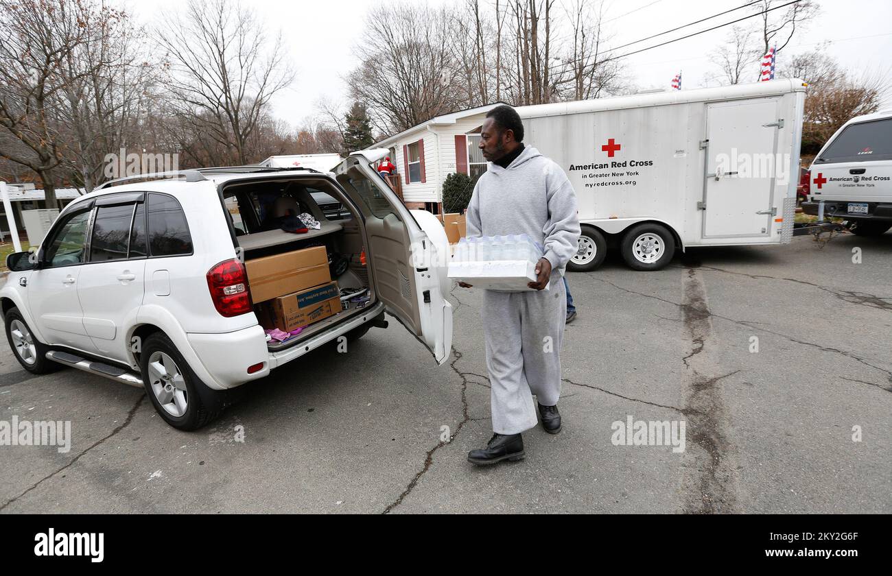 Stoney Point, New York, 1. Dezember 2012 Freiwilliger des Roten Kreuzes Lionel Mathis stellt Wasser in das Fahrzeug eines Überlebenden des Hurricane Sandy in Stoney Point, New York, 1. Dezember 2012. Die FEMA arbeitet mit verschiedenen Partnern zusammen, darunter Bundes-, Landes-, Kommunal- und Stammesregierungen, ehrenamtliche religiöse und kommunale Organisationen sowie der Privatsektor, um die vom Hurrikan Sandy betroffenen Bewohner zu unterstützen. Chris Kleponis/FEMA. New York Hurrikan Sandy. Fotos zu Katastrophen- und Notfallmanagementprogrammen, Aktivitäten und Beamten Stockfoto